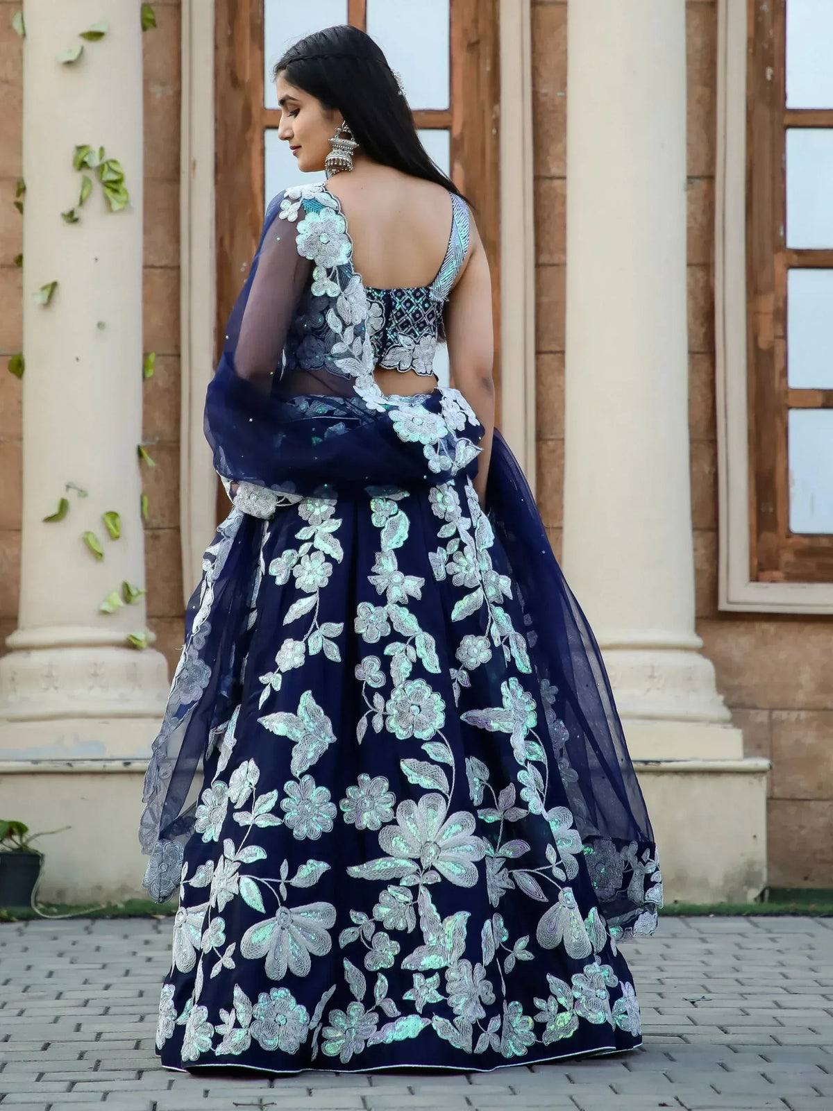 Navy blue designer lehenga choli with floral embroidery and sheer dupatta, perfect for Indian ethnic wear occasions.