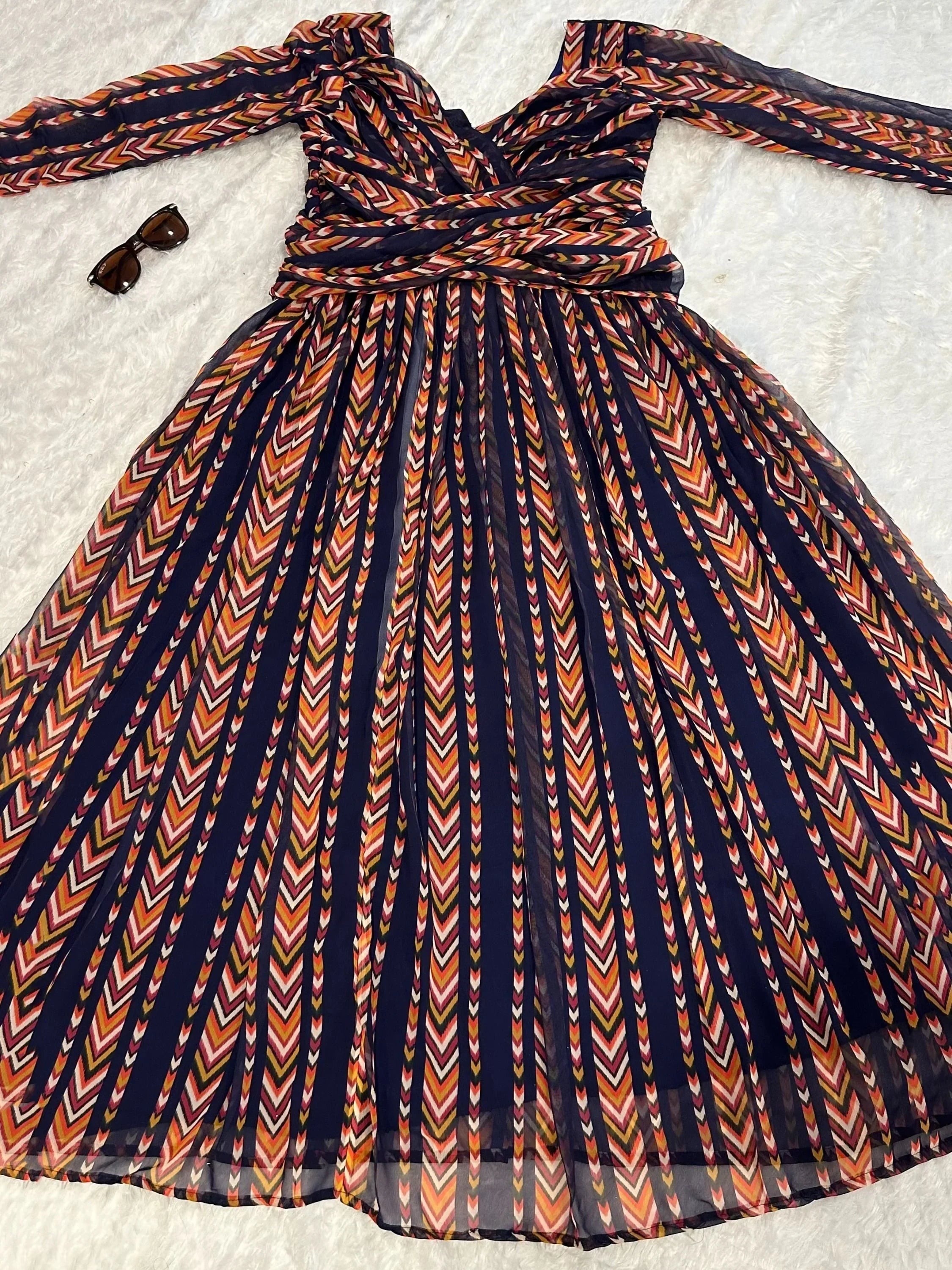 Long-sleeve navy ethnic gown with colorful chevron pattern and matching sunglasses