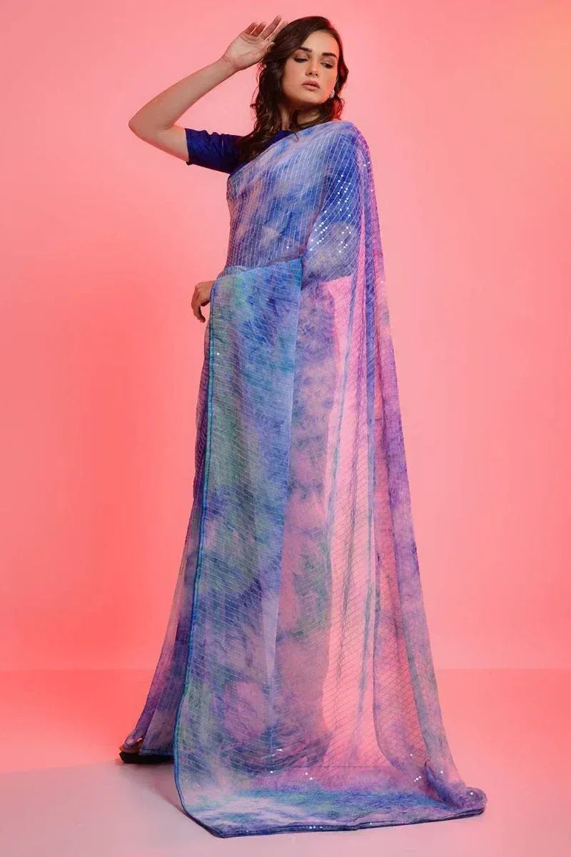 Woman in blue and purple tie-dye saree with sequins, styled for ethnic occasions