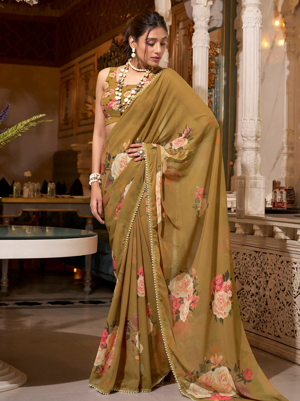 Olive green floral print saree with pearl border, styled with matching blouse and ethnic jewelry