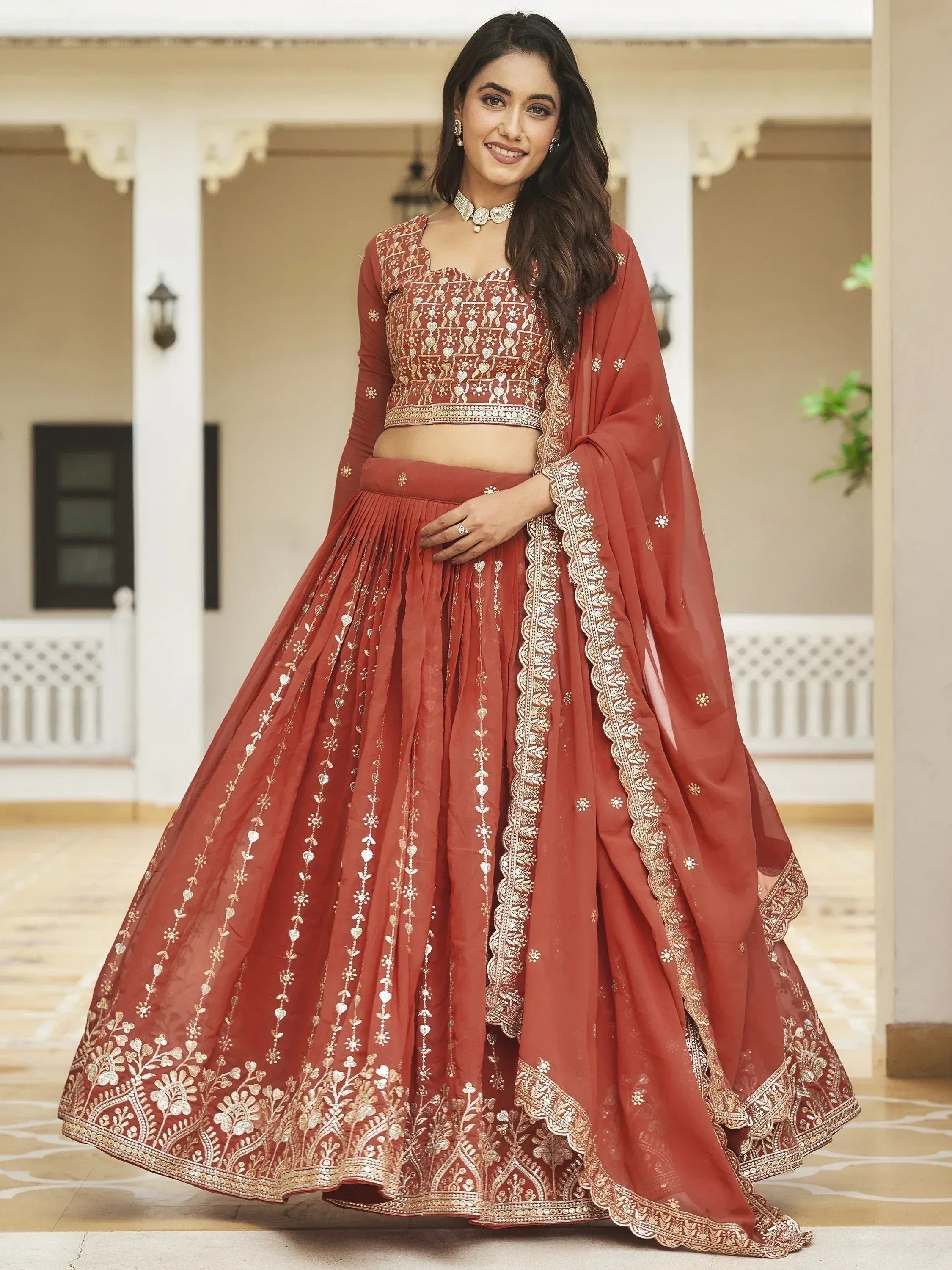 Red embroidered lehenga choli with gold detailing, perfect for Indian weddings and festive occasions.