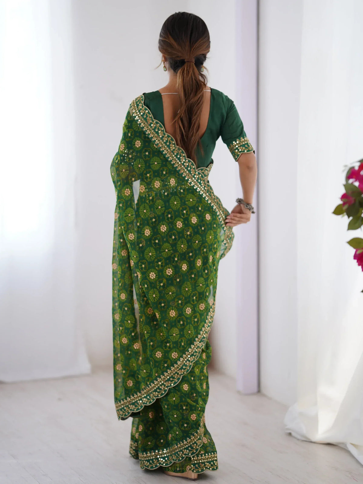 Green floral printed saree with gold embroidery and scalloped border, paired with matching blouse