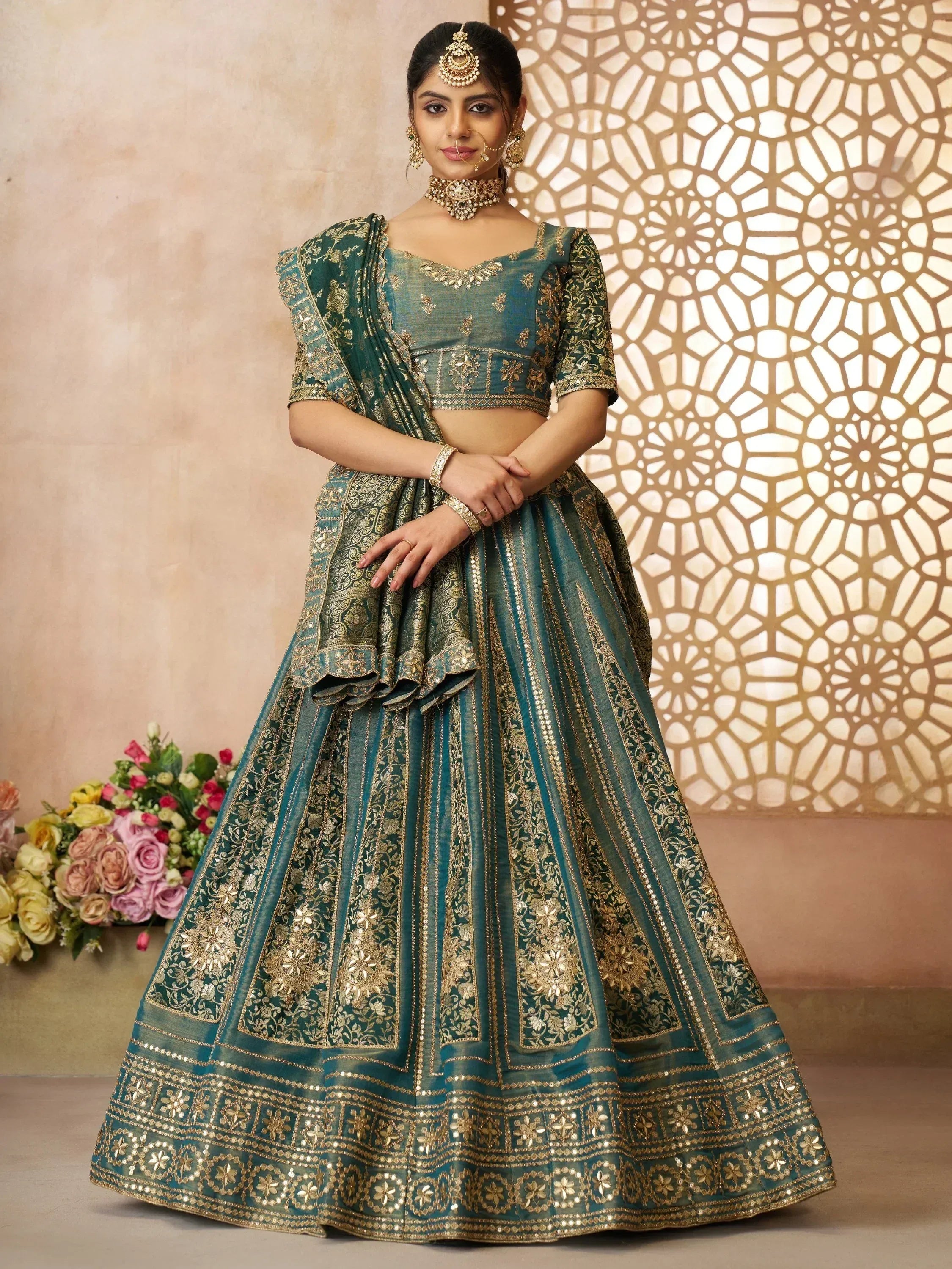 Teal green designer lehenga choli with gold embroidery, perfect for Indian weddings and festive occasions.