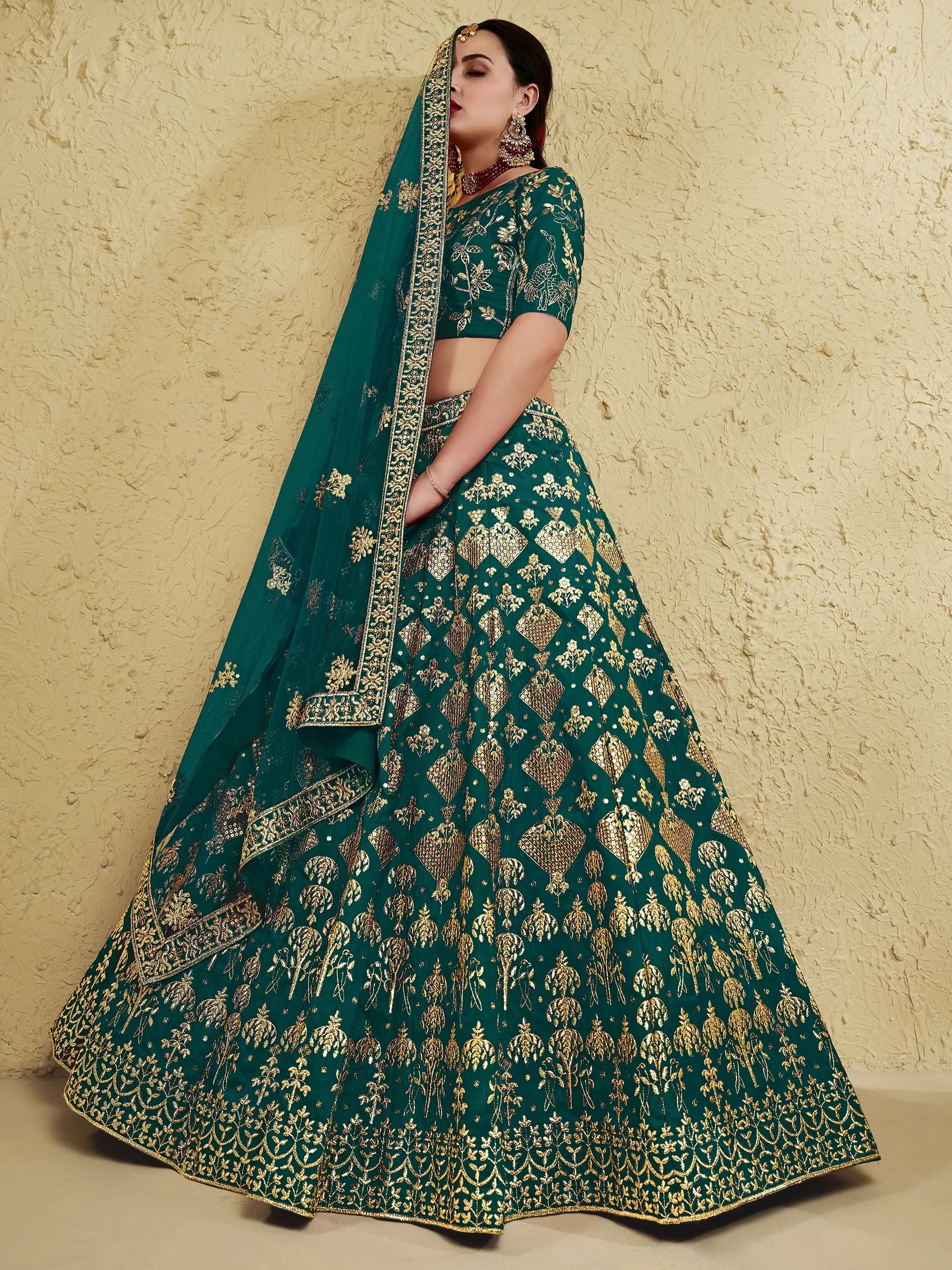 Emerald green lehenga choli with gold embroidery, perfect for Indian weddings and festive occasions.