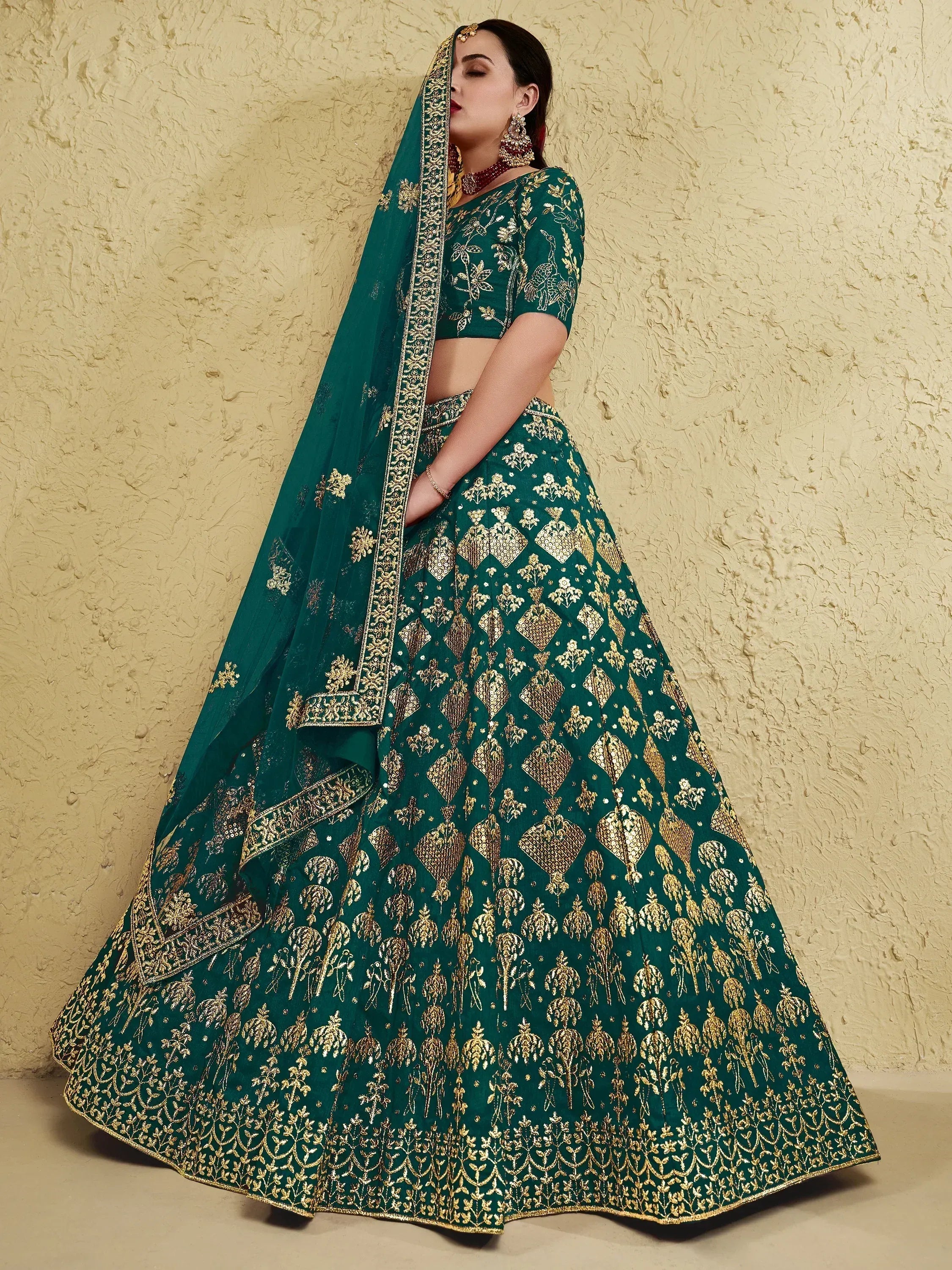 Emerald green lehenga choli with gold embroidery, perfect for Indian weddings and festive occasions.