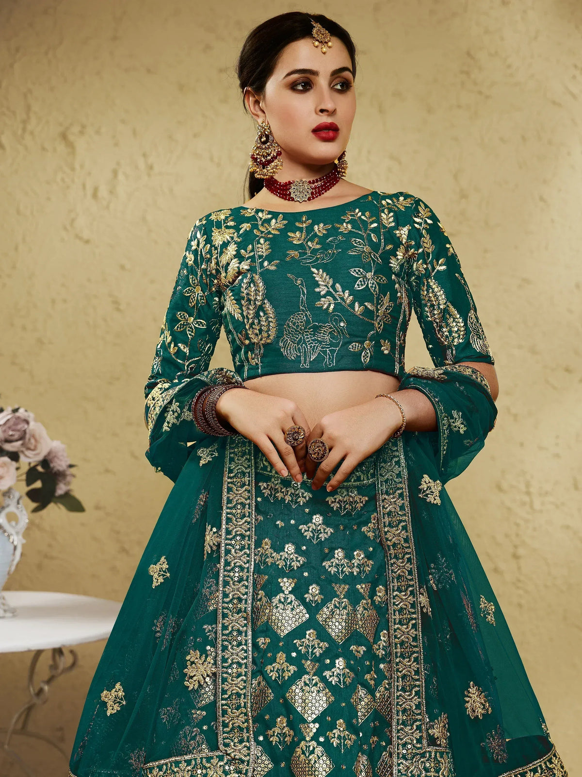 Emerald green designer lehenga choli with gold embroidery and peacock motifs, perfect for Indian weddings and festive occasions.