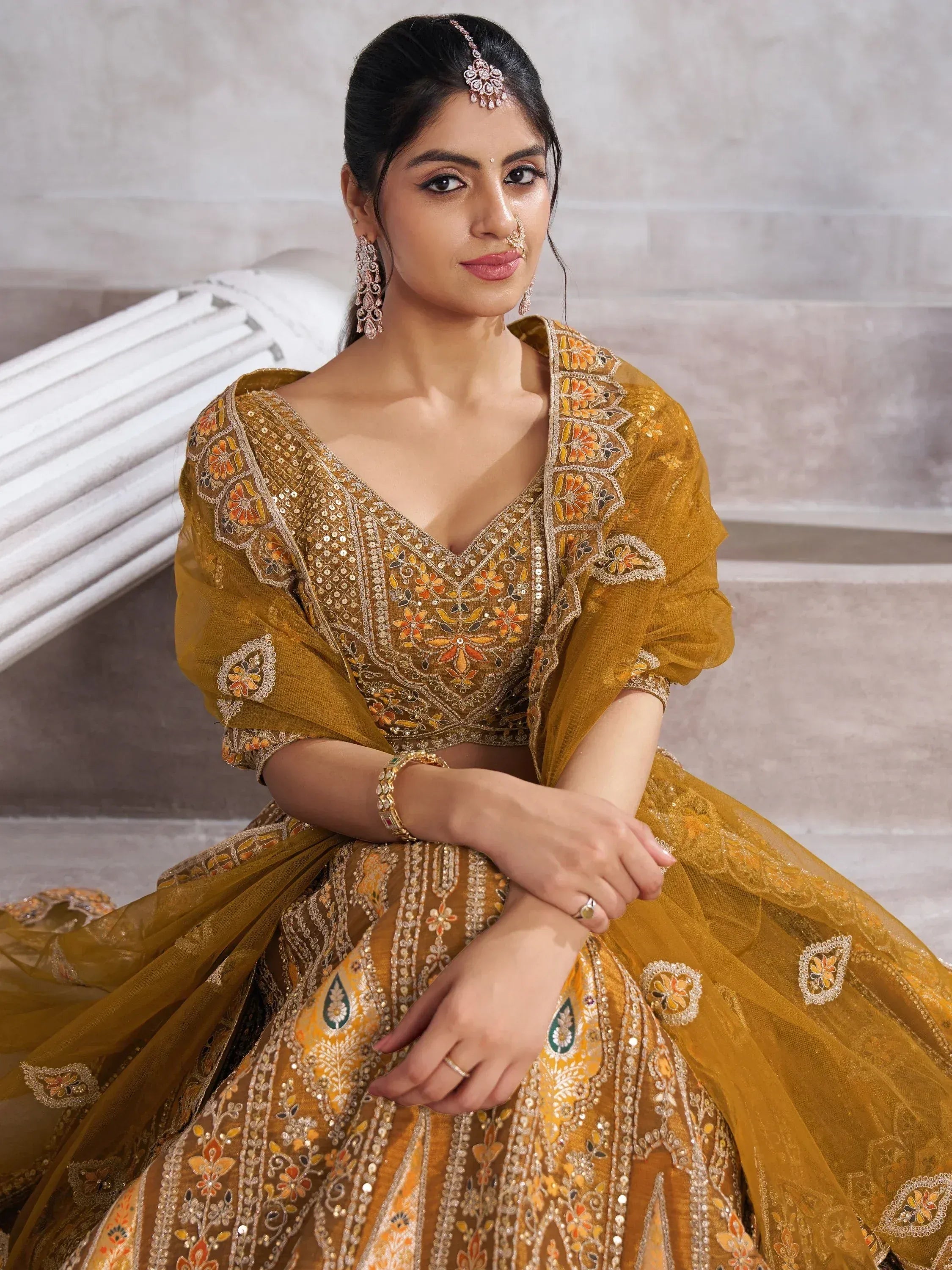 Mustard yellow designer lehenga choli with floral embroidery and sequins, perfect for Indian weddings and festivals.