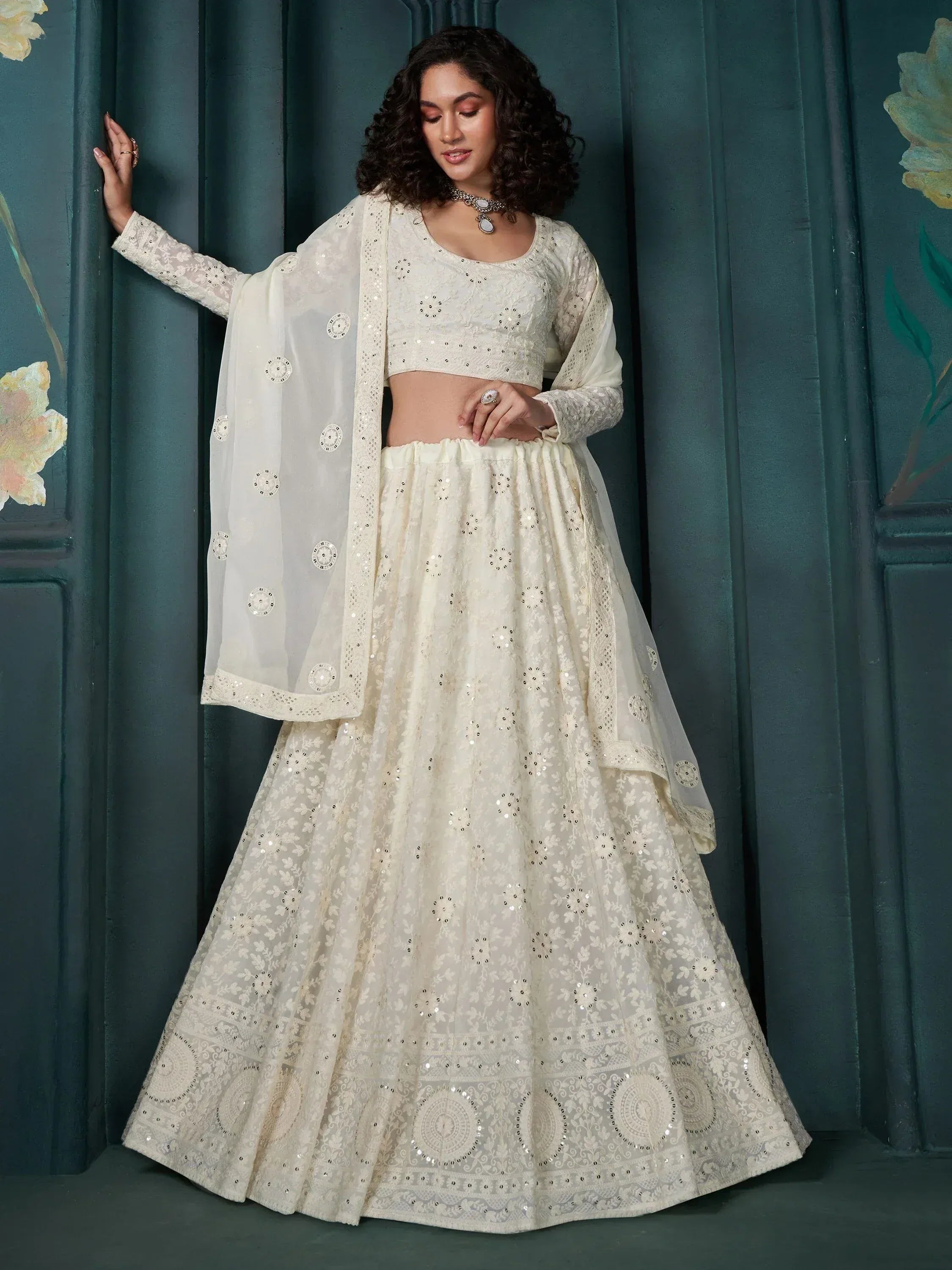 Elegant ivory lehenga choli with floral embroidery and mirror work, perfect for Indian ethnic occasions.