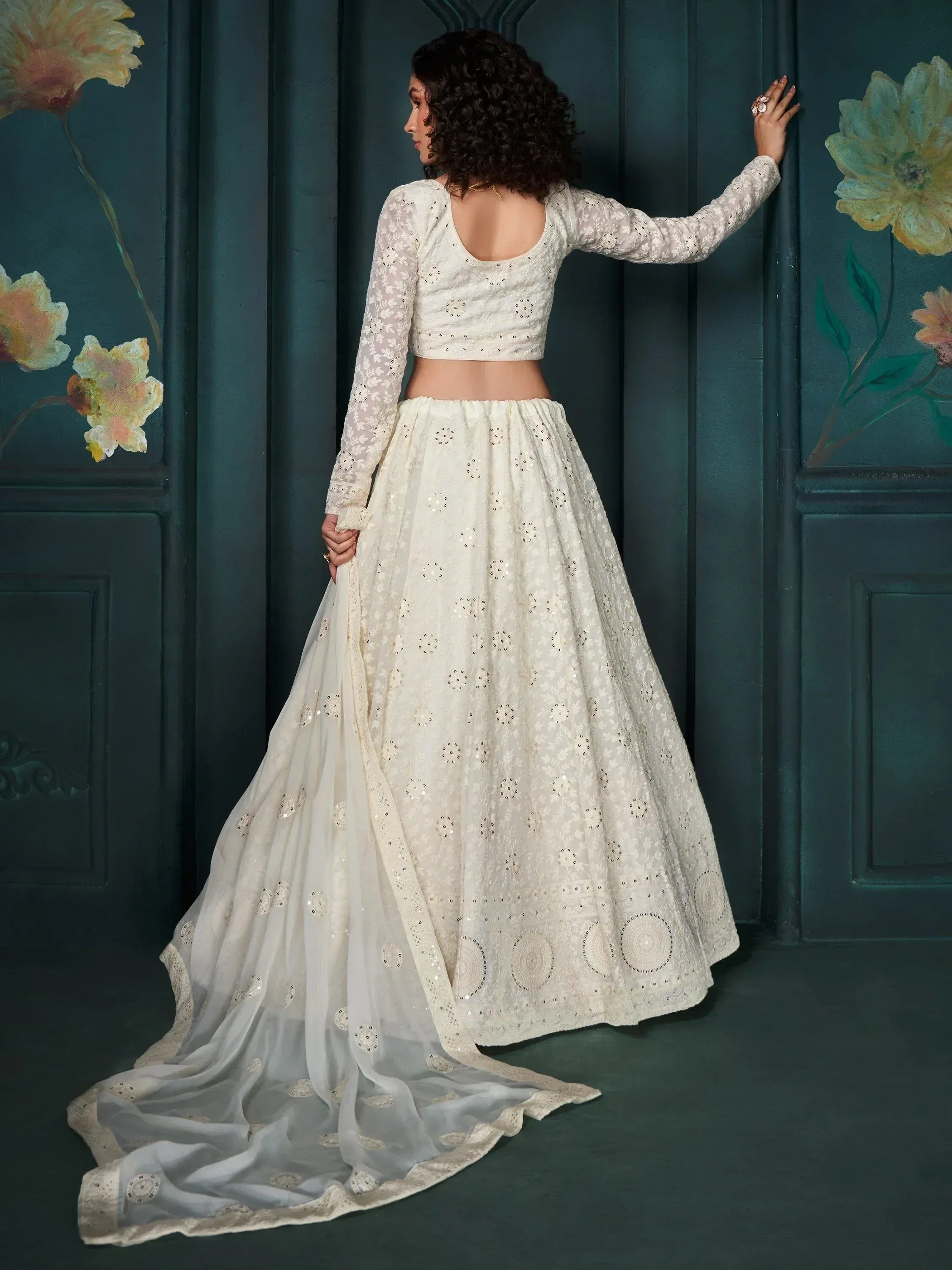 Elegant white embroidered lehenga choli with sheer dupatta, perfect for Indian weddings and festive occasions.