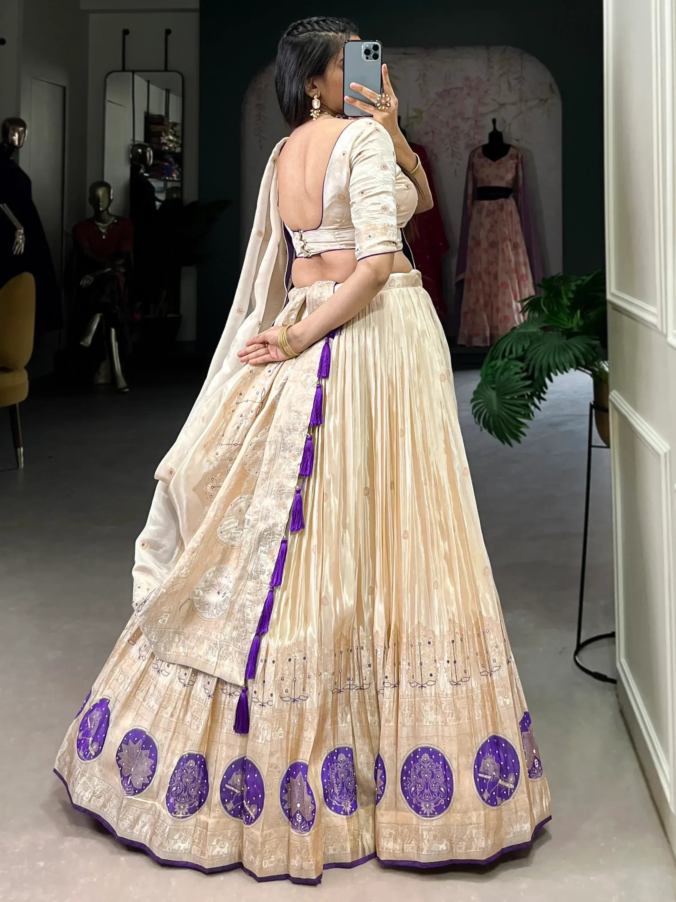 Cream and purple designer lehenga choli with embroidered motifs and tassels, back view