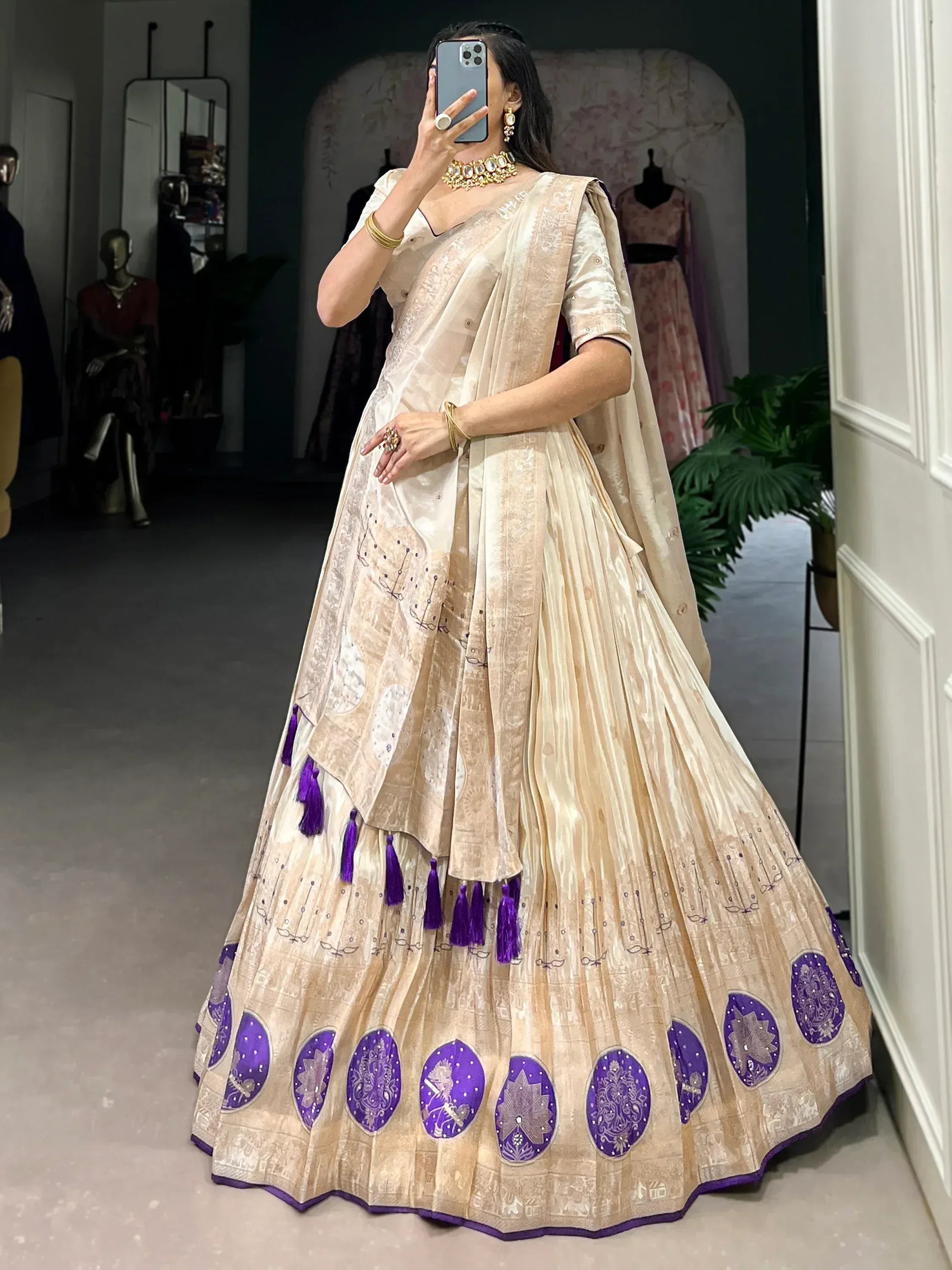Elegant beige lehenga choli with purple embroidery and tassels, perfect for Indian ethnic wear occasions