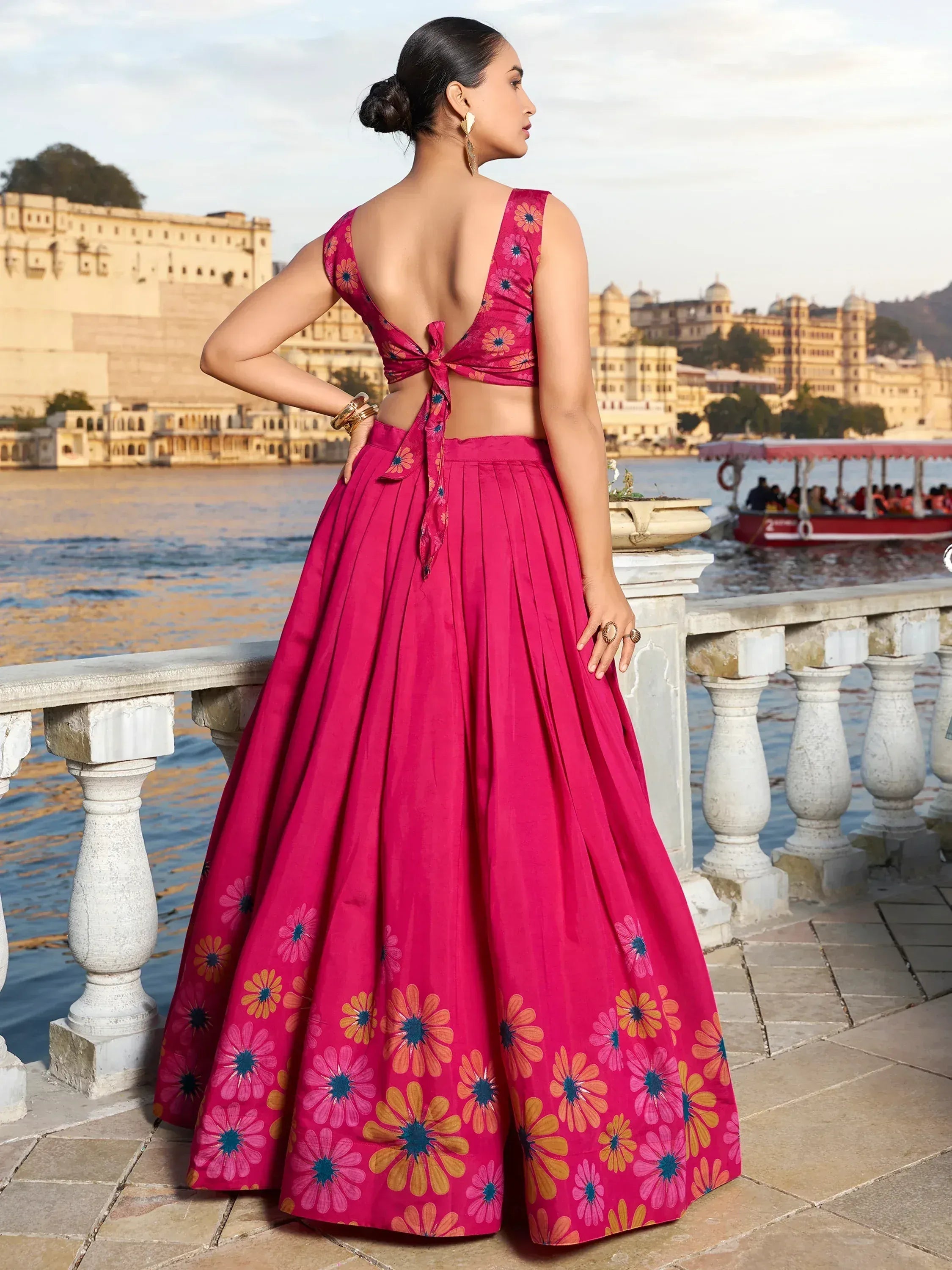 Pink floral lehenga choli with back tie, worn by woman overlooking lake palace, ideal for Indian ethnic events