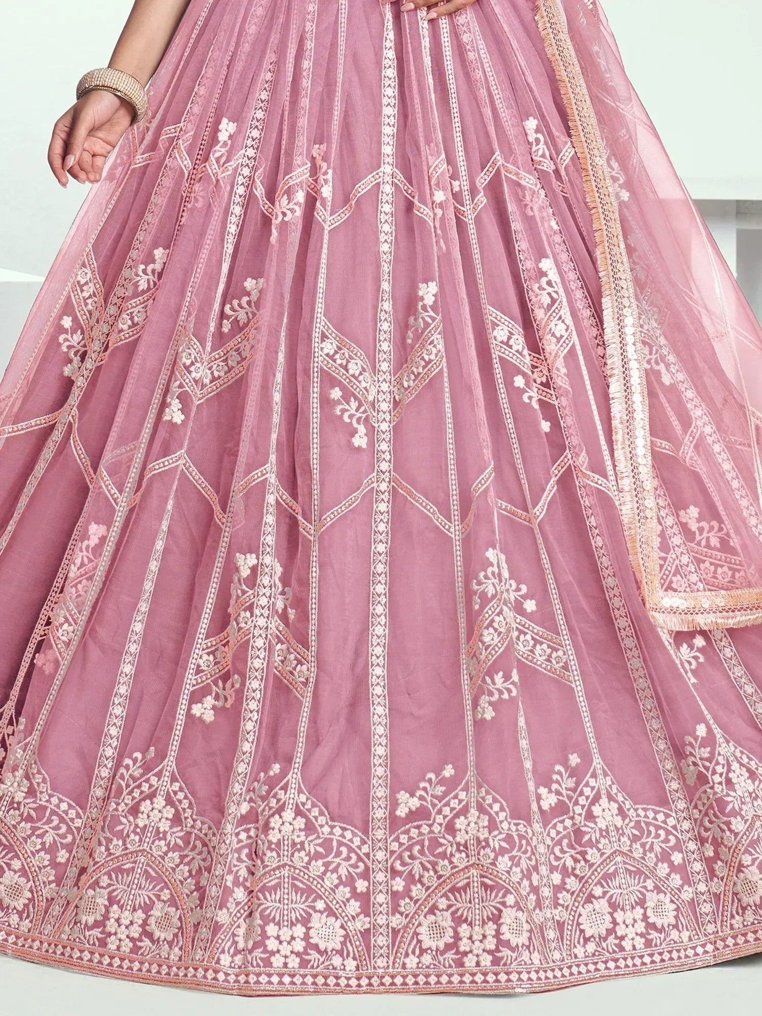 Pink embroidered lehenga with floral patterns and gold trim, perfect for Indian ethnic wear
