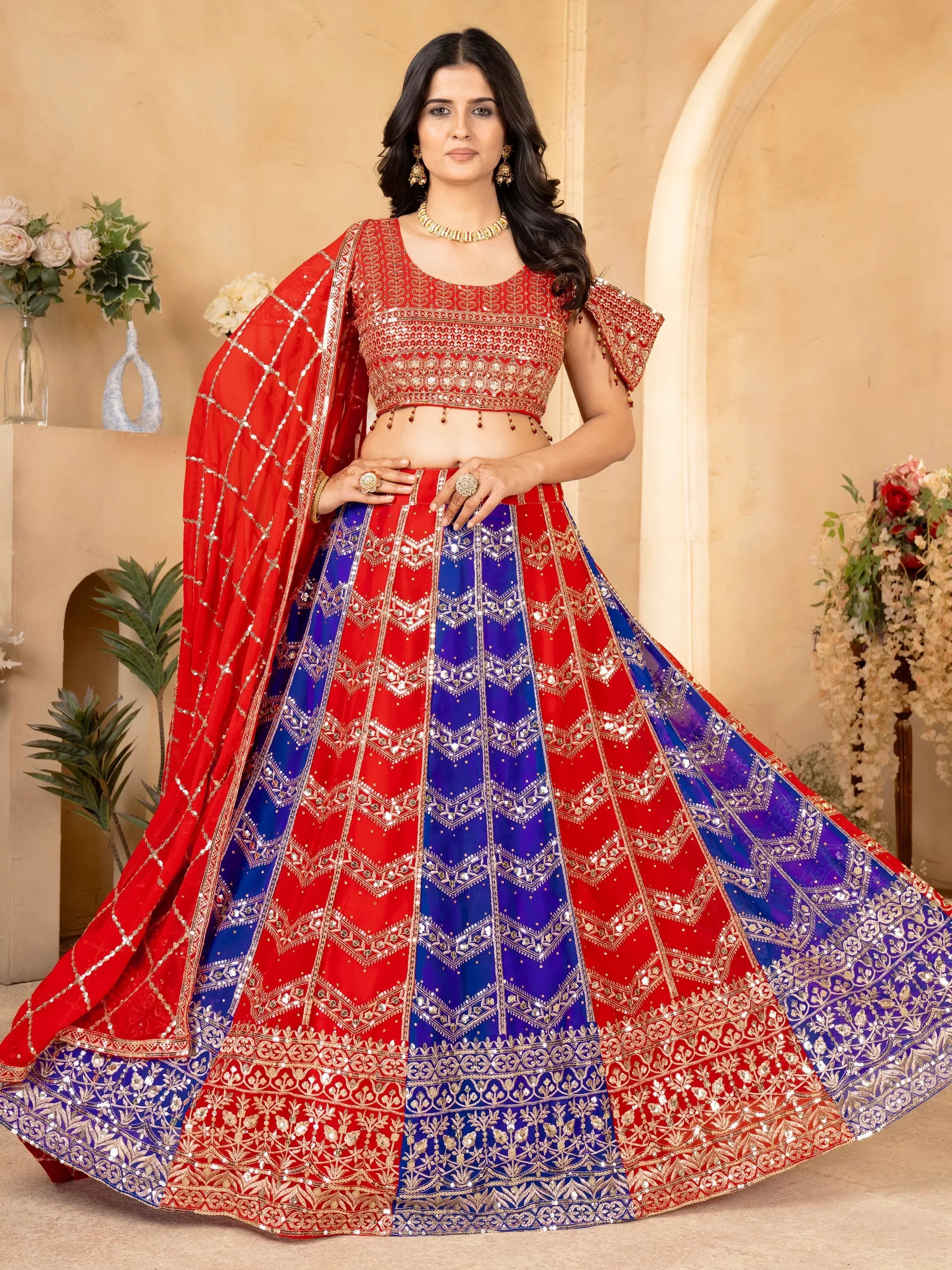 Red and blue designer lehenga choli with intricate embroidery and sequins, perfect for Indian weddings and festive occasions.