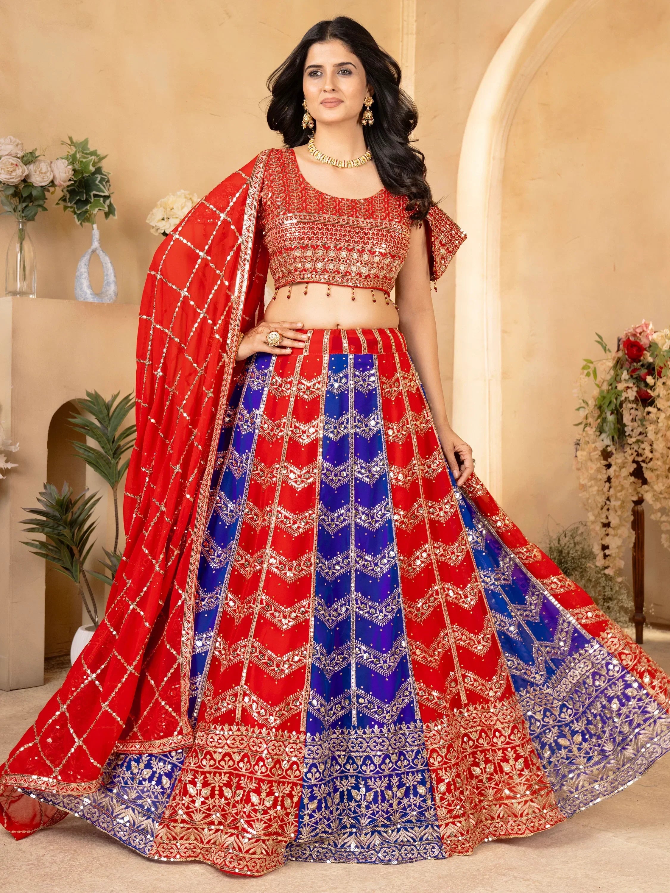 Red and blue designer lehenga choli with gold embroidery and sequins, perfect for Indian weddings and festivals