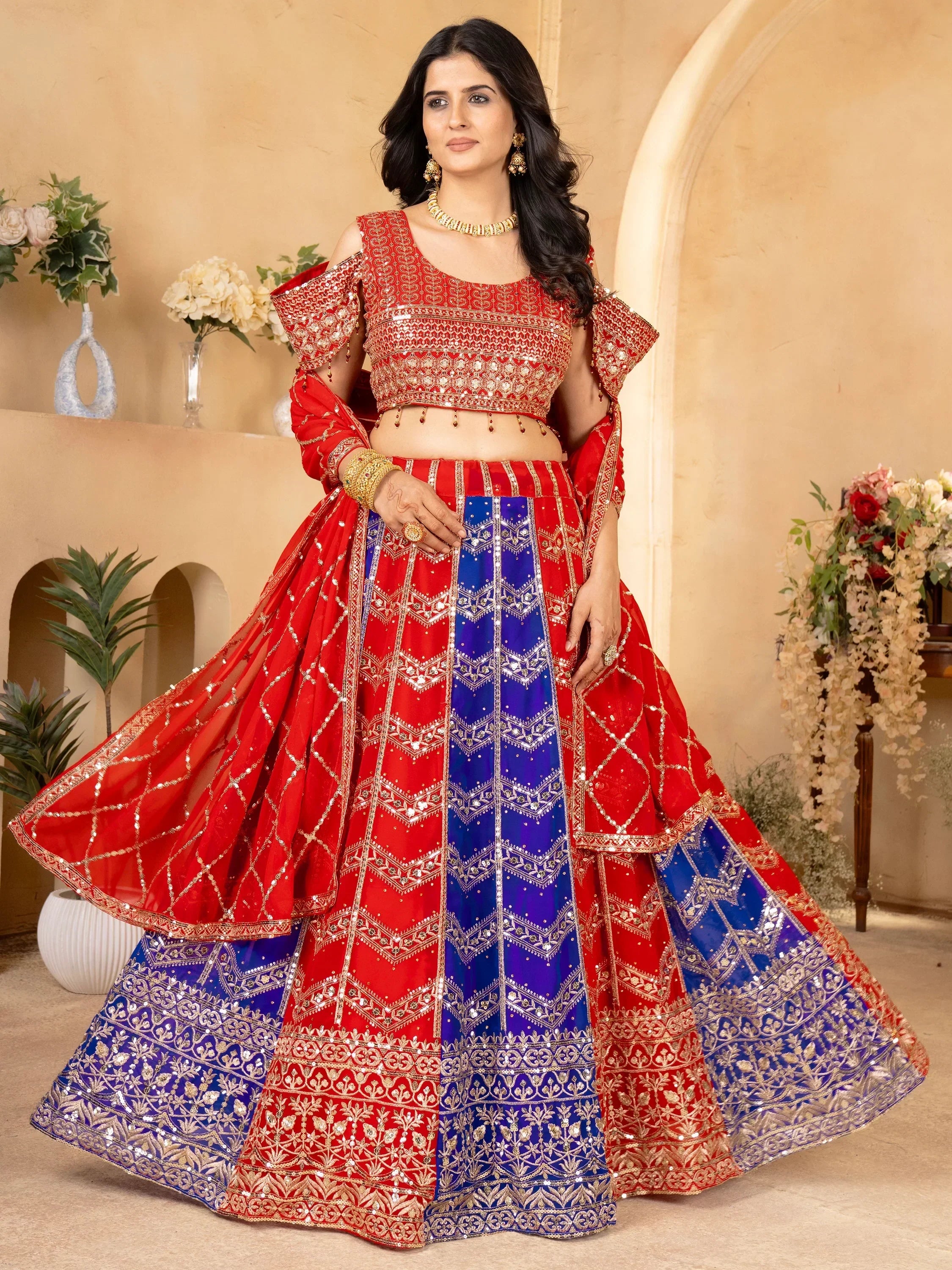 Red and blue designer lehenga choli with gold embroidery, perfect for Indian weddings and festive occasions.