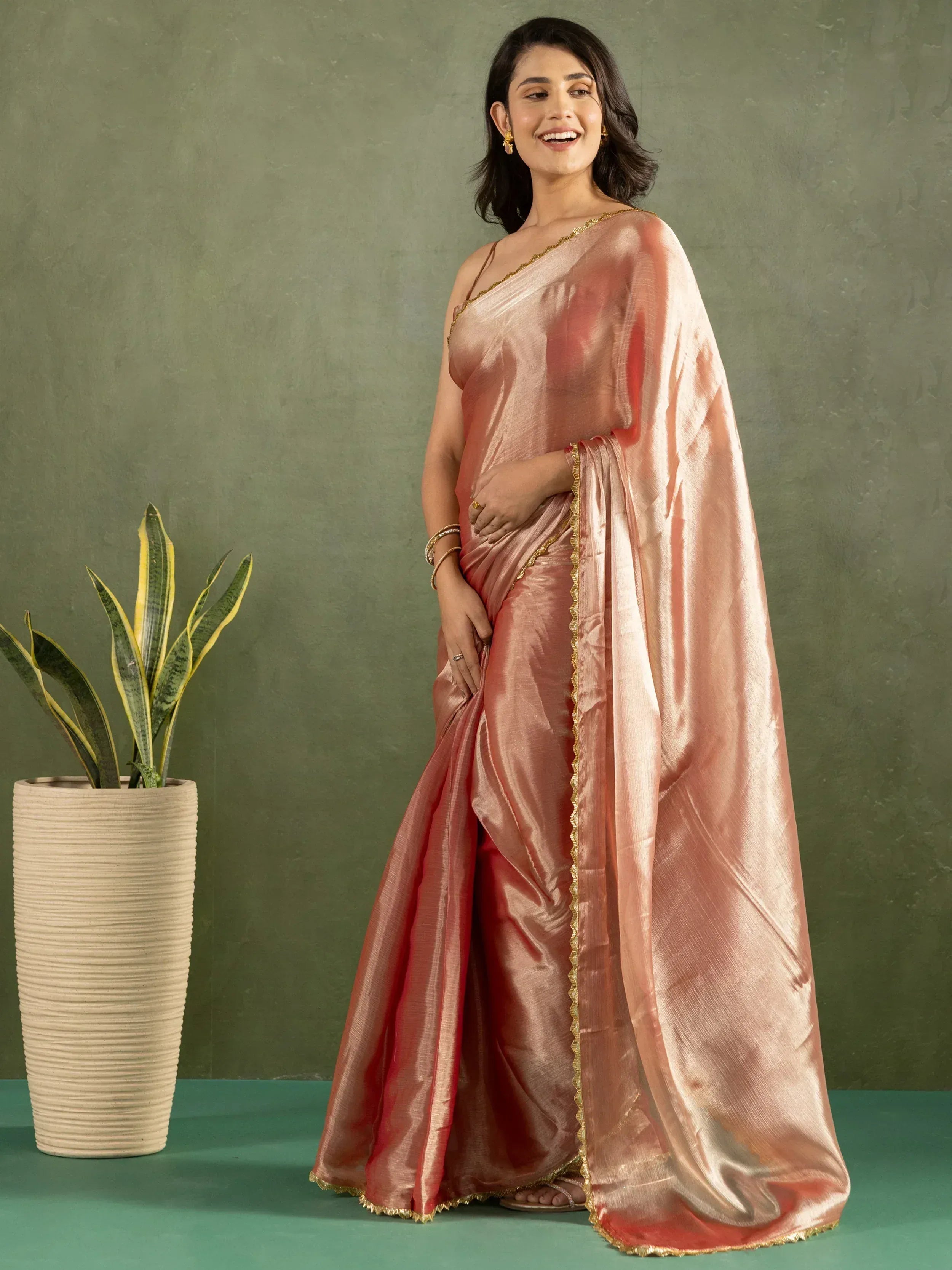 Woman in elegant peach silk saree with gold trim, perfect for Indian ethnic occasions