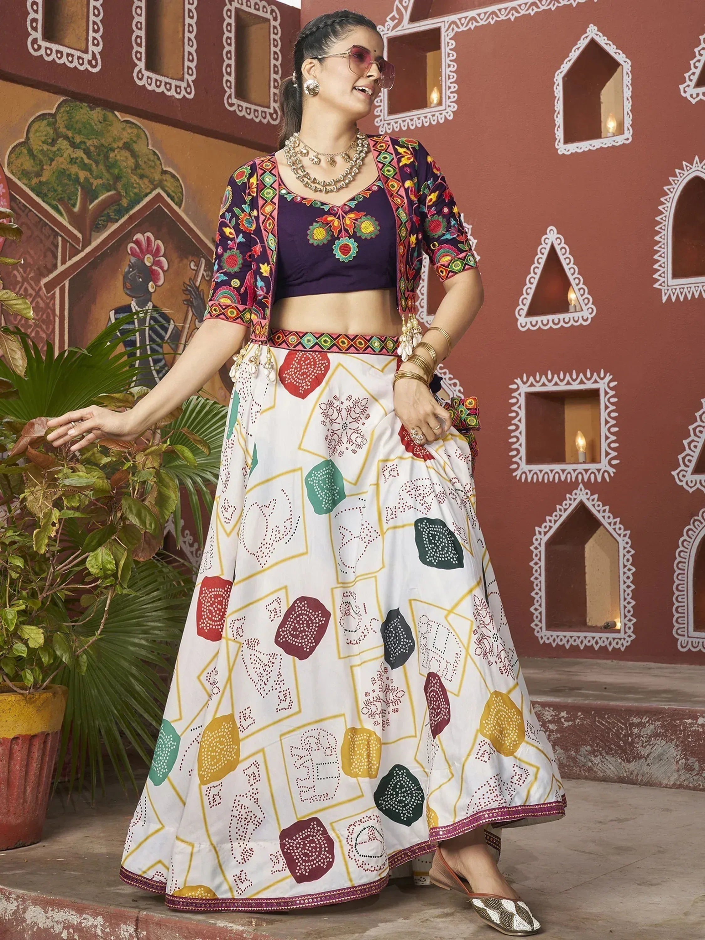 Woman in colorful embroidered lehenga choli with floral motifs, traditional Indian ethnic wear