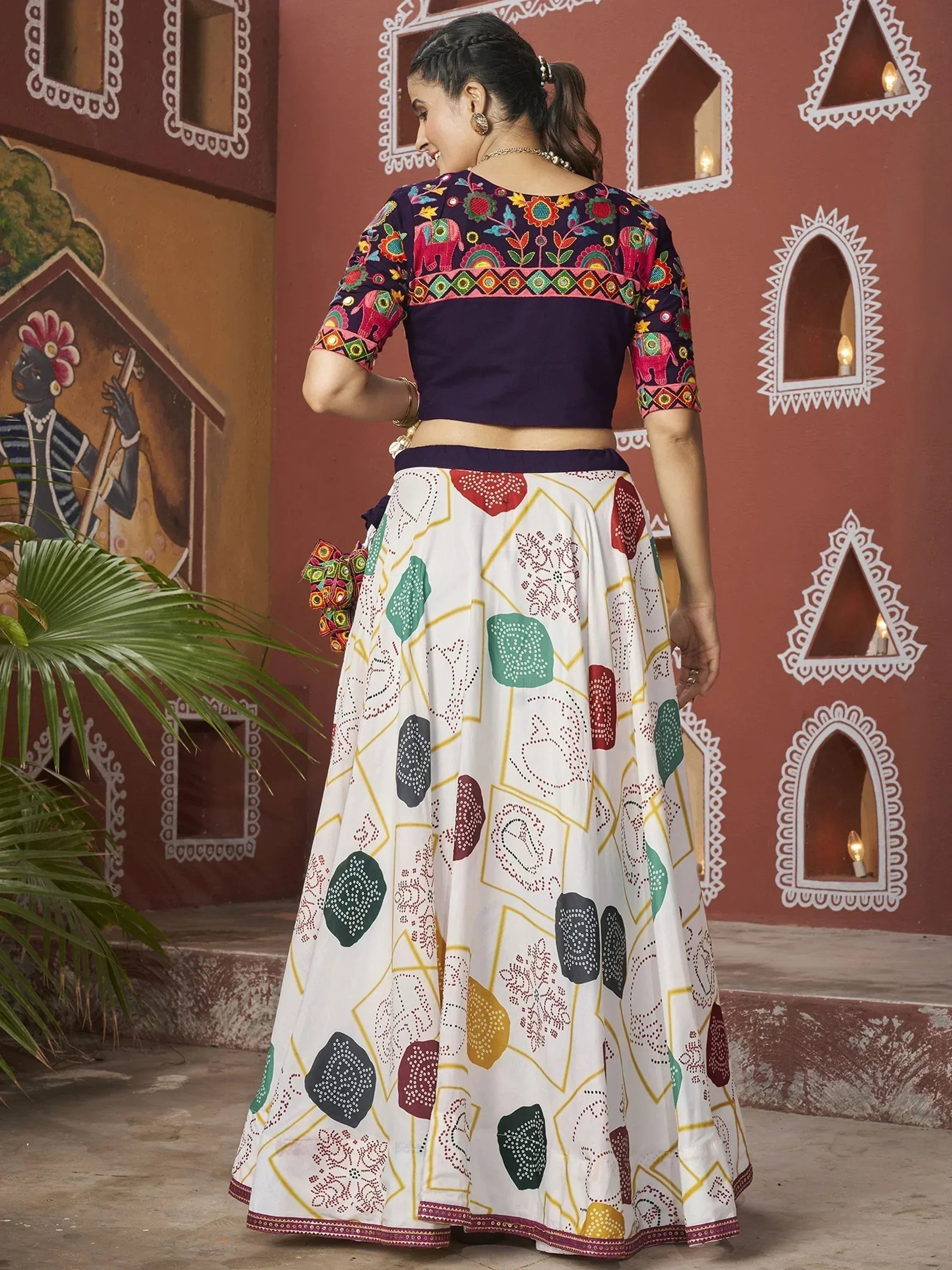 Woman in colorful embroidered lehenga choli with elephant motifs, Indian ethnic wear