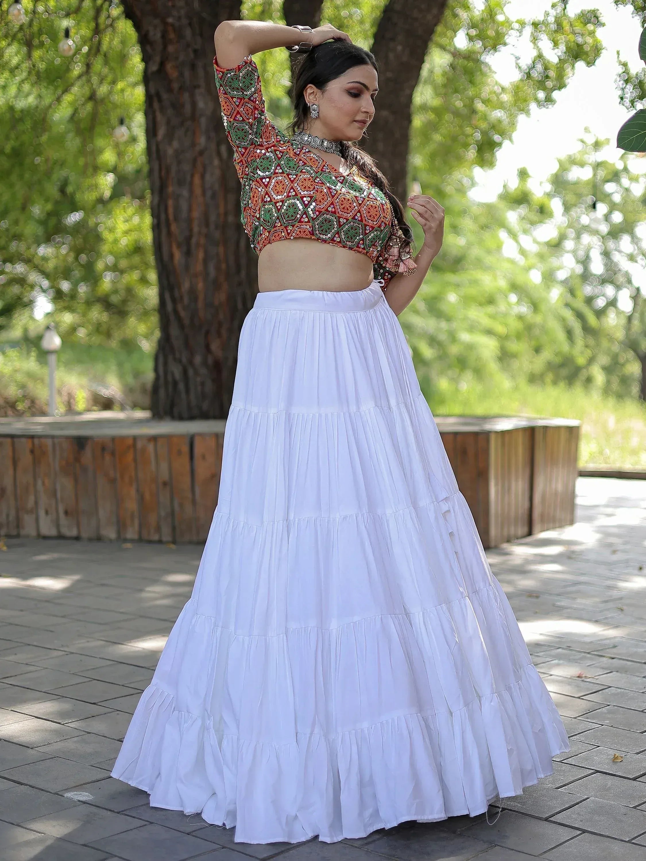 Woman in embroidered red green crop top with white tiered skirt, Indian ethnic wear