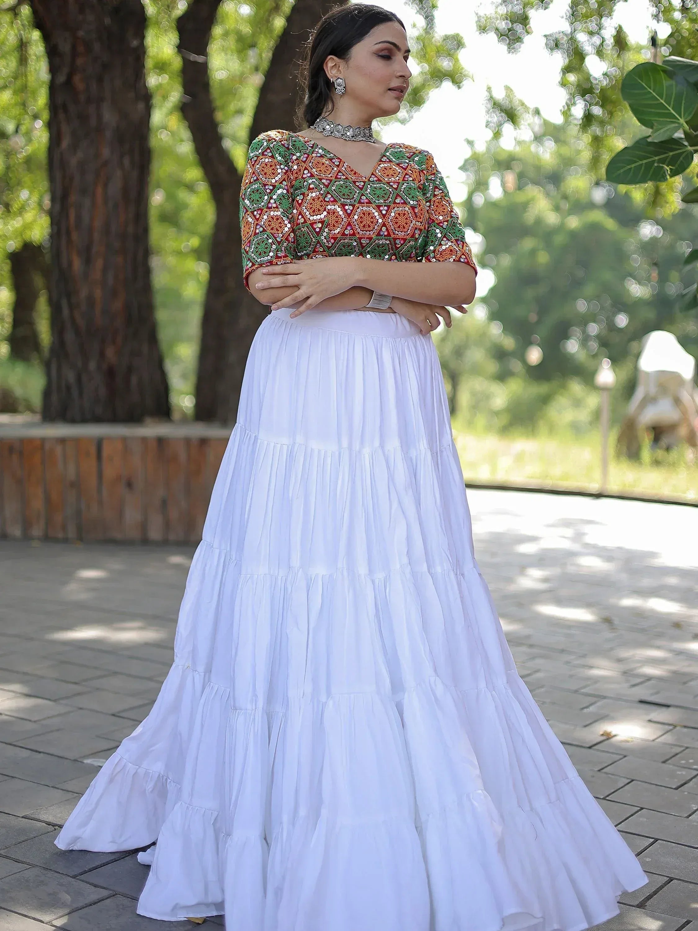 Woman in colorful embroidered top and white tiered skirt, Indian ethnic wear