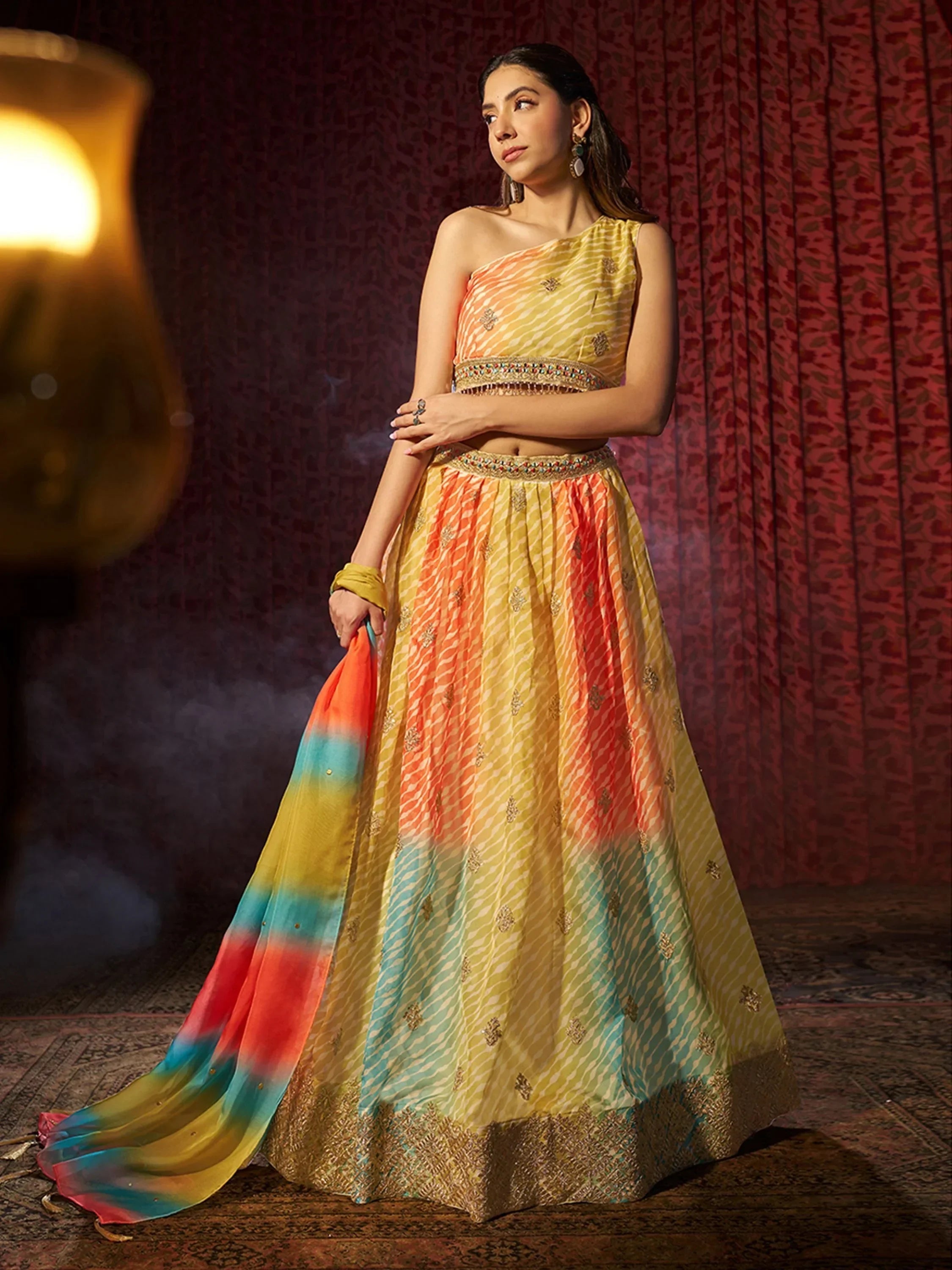 Vibrant yellow and orange lehenga choli with embroidered detailing and colorful dupatta, perfect for Indian ethnic occasions.