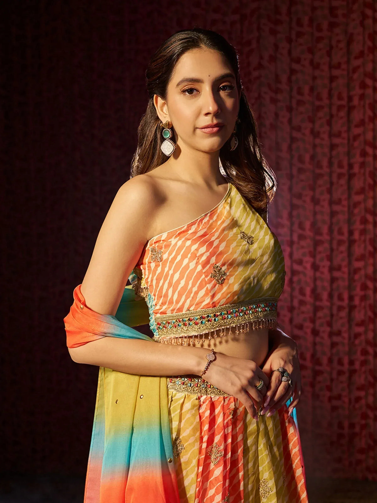 Colorful one-shoulder lehenga choli with embroidered detailing and ombre dupatta, perfect for Indian ethnic occasions.
