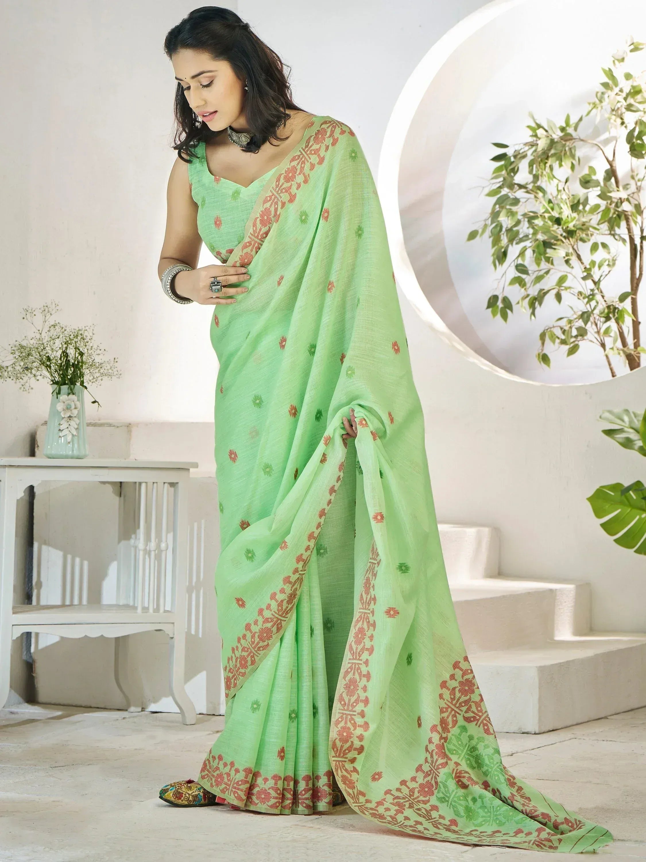 Mint green ethnic saree with red floral border, perfect for Indian occasions and festive wear.