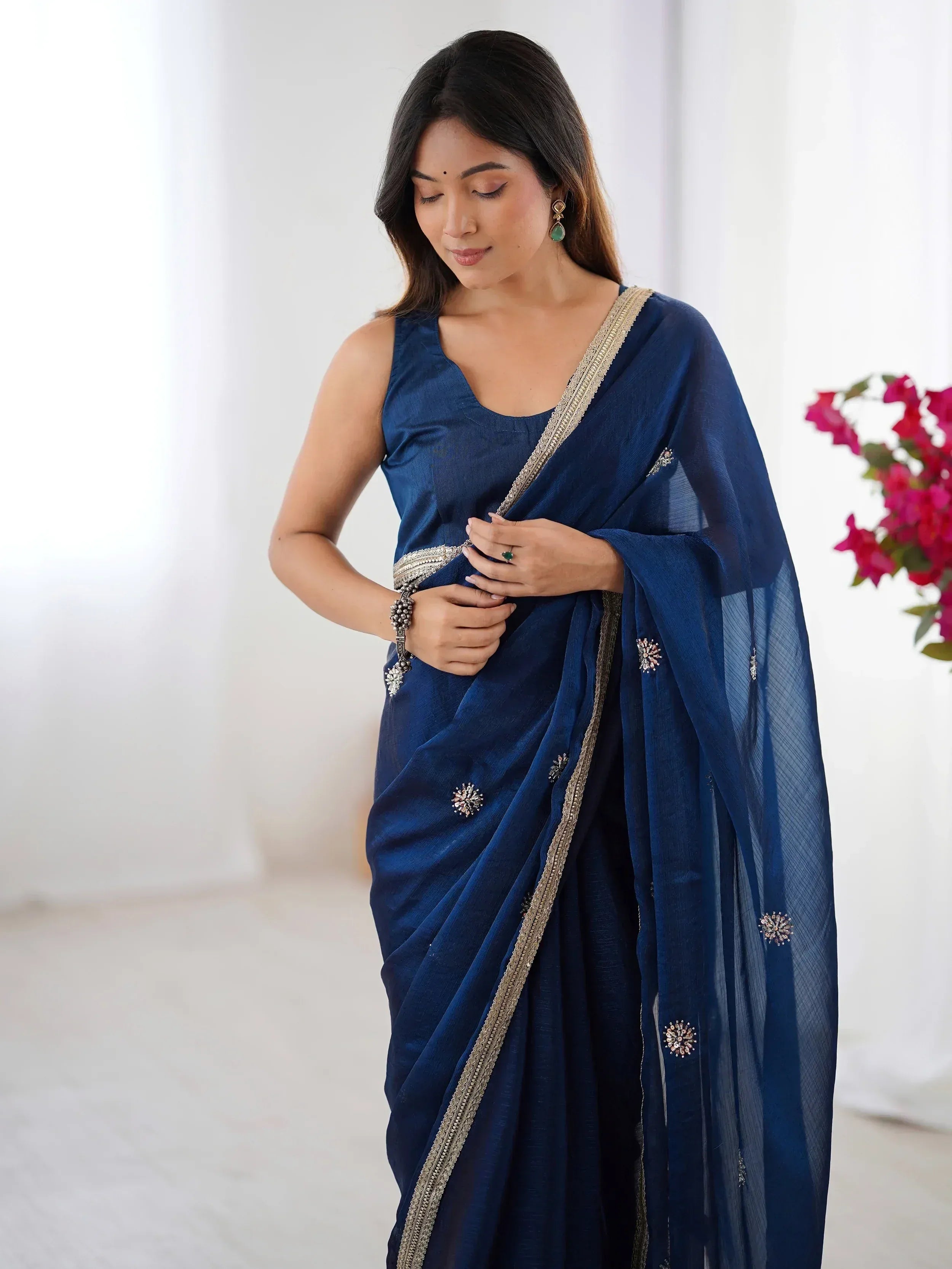 Elegant navy blue saree with gold border and floral embellishments, paired with matching blouse for Indian ethnic wear.
