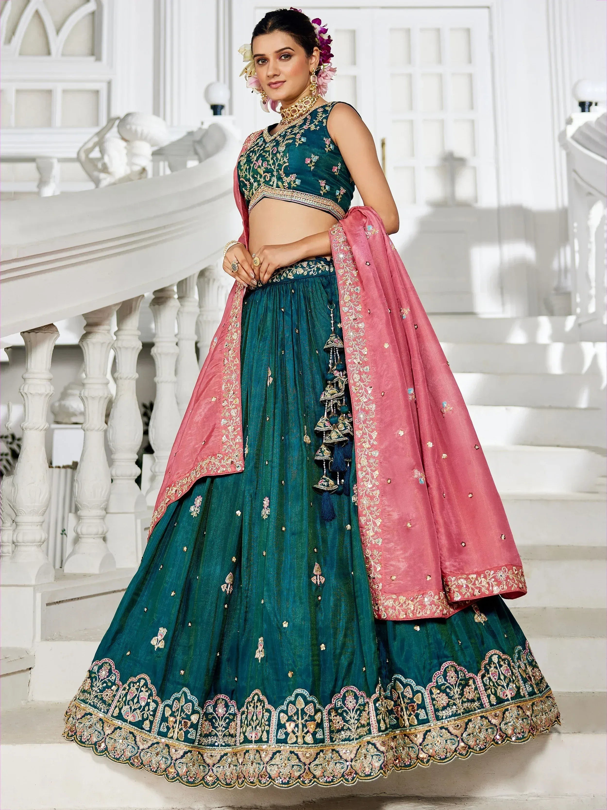 Teal embroidered lehenga choli with pink dupatta, perfect for Indian weddings and festive occasions.