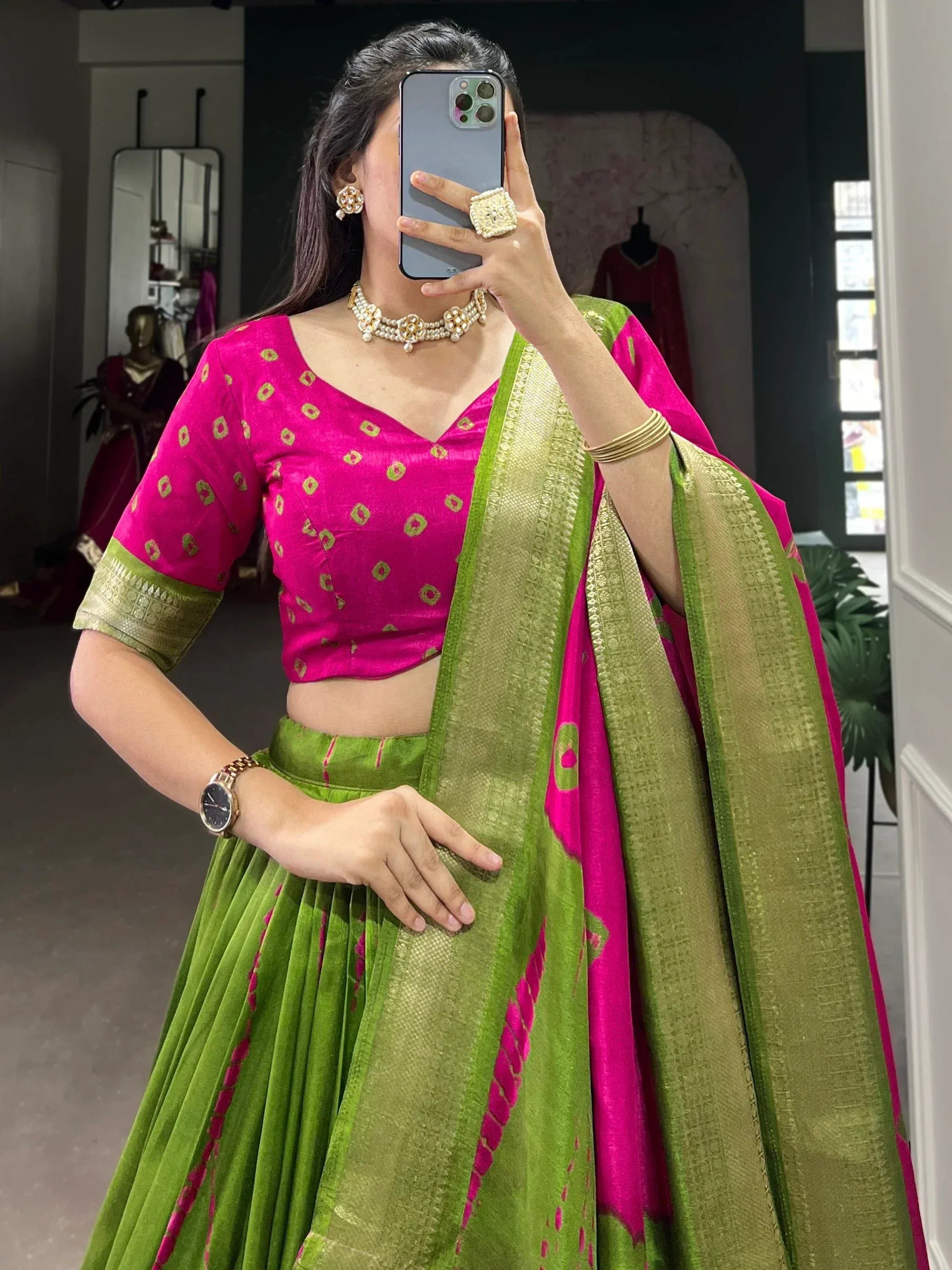 Vibrant pink and green Indian lehenga choli with gold embroidery, perfect for festive occasions.