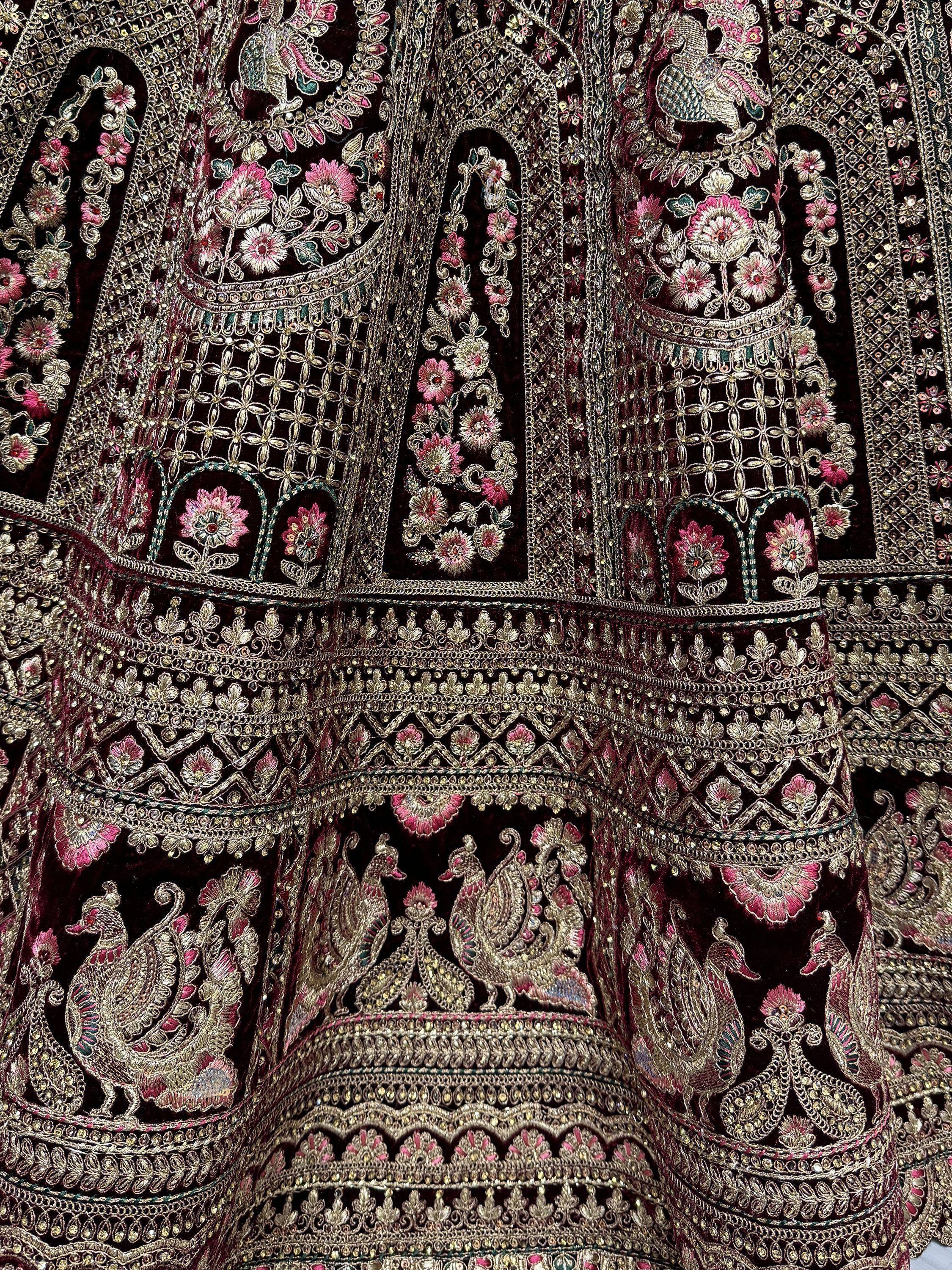 Luxury Indian ethnic wear with intricate gold embroidery, floral patterns, and peacock motifs on dark velvet fabric.