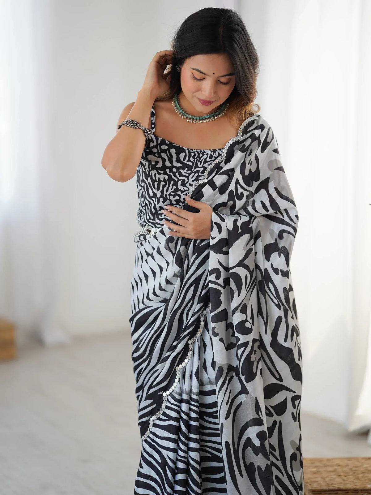 Black and white abstract print saree with crystal embellishments, styled with statement jewelry for ethnic wear.