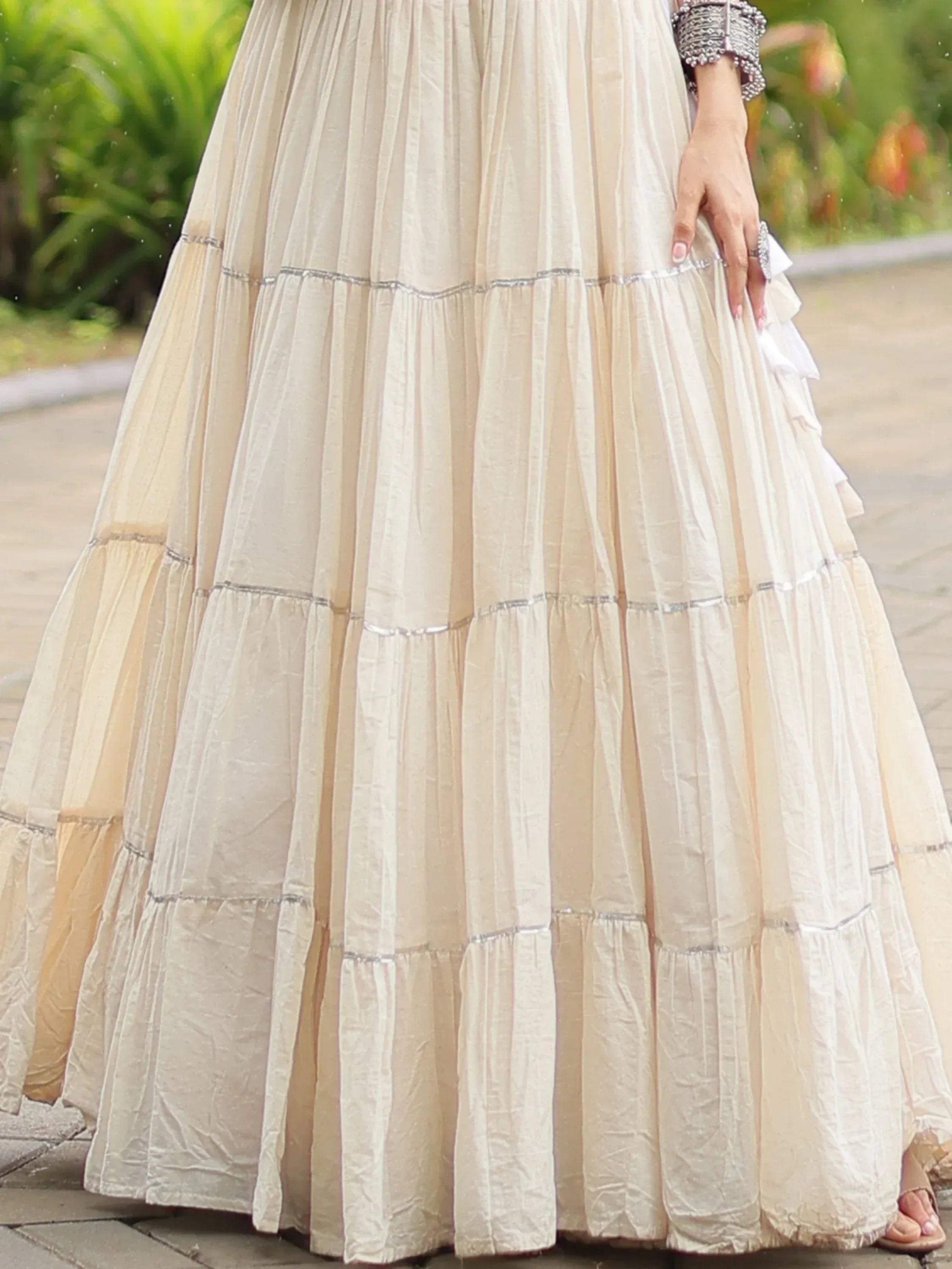 Cream tiered ethnic gown with silver trim, perfect for Indian occasions and festive wear
