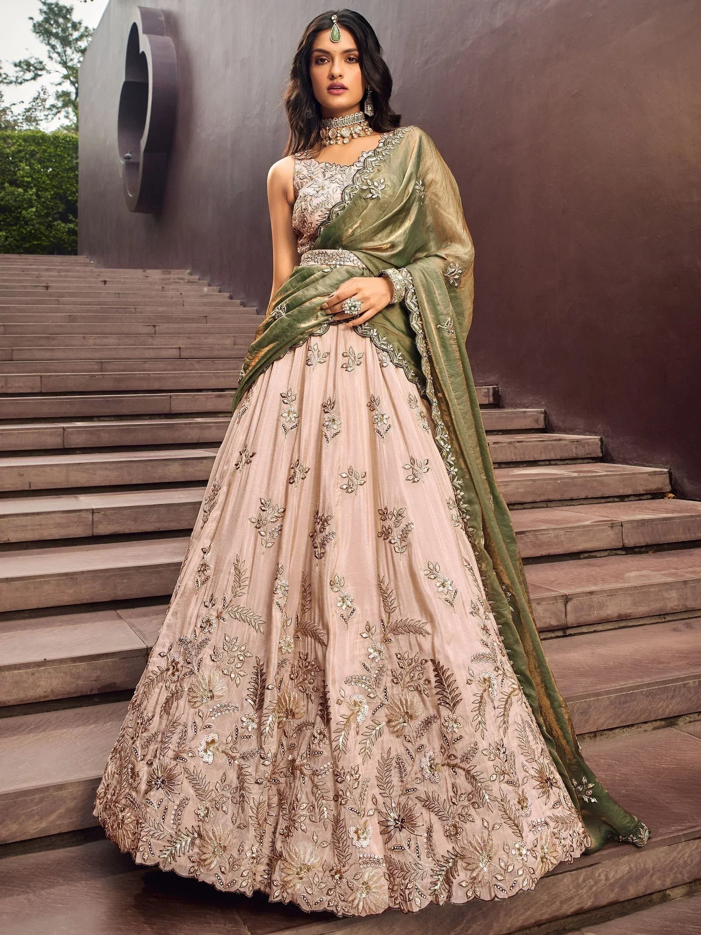 Elegant beige embroidered lehenga choli with green dupatta, perfect for Indian weddings and festive occasions.