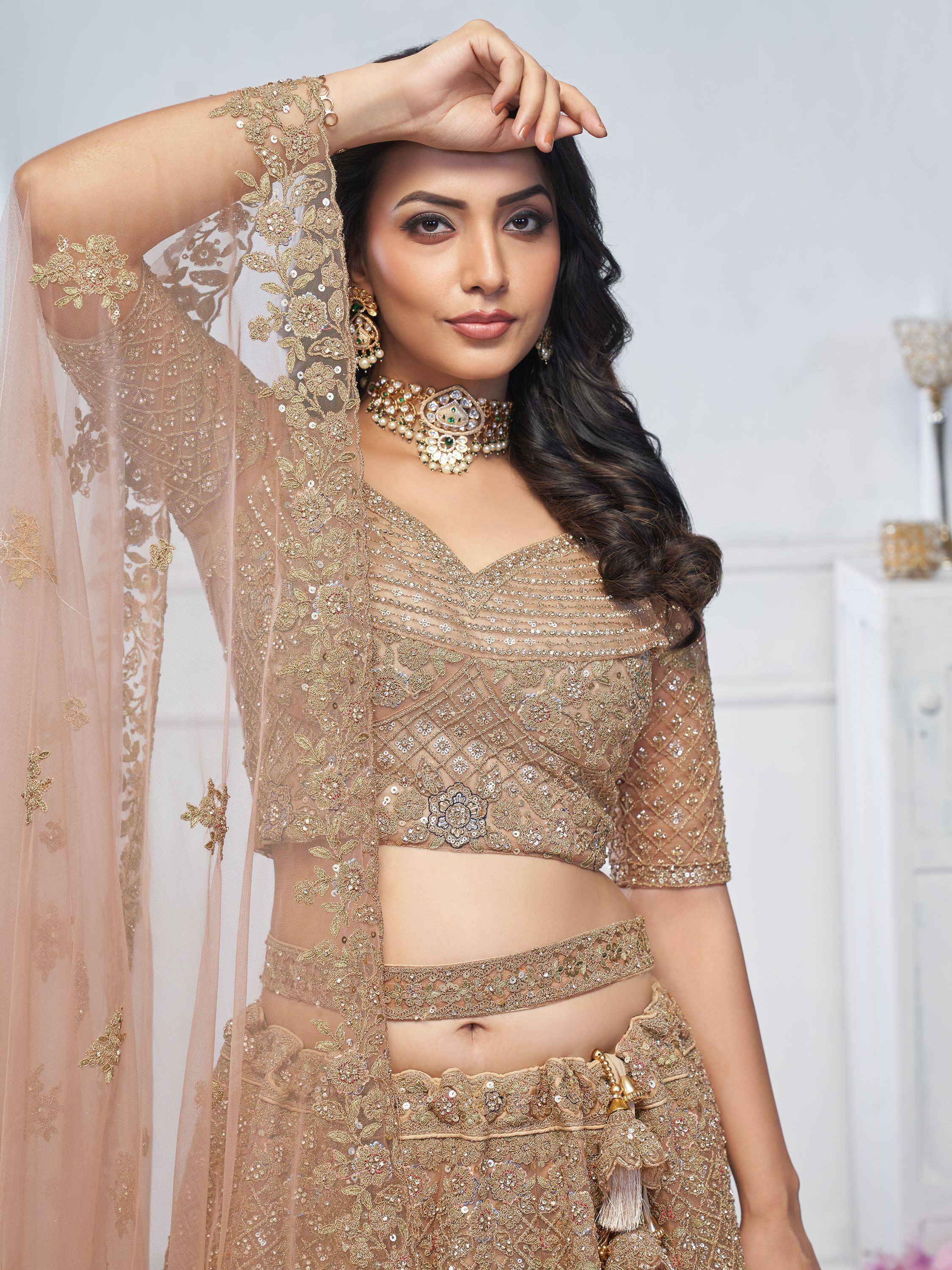Elegant gold embroidered lehenga choli with sheer dupatta, perfect for Indian weddings and festive occasions.
