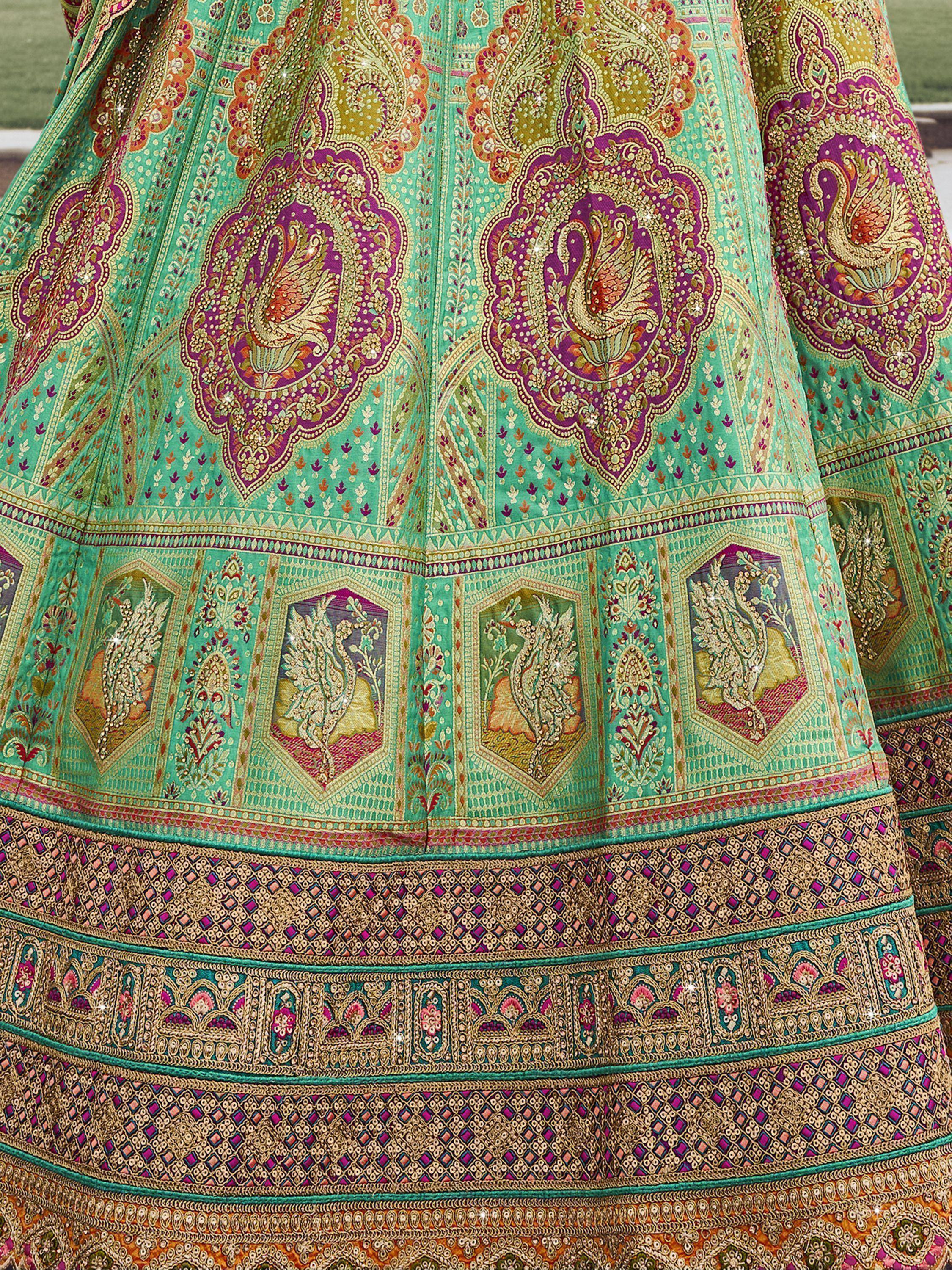 Turquoise lehenga with peacock motifs and intricate gold embroidery, perfect for Indian ethnic wear.