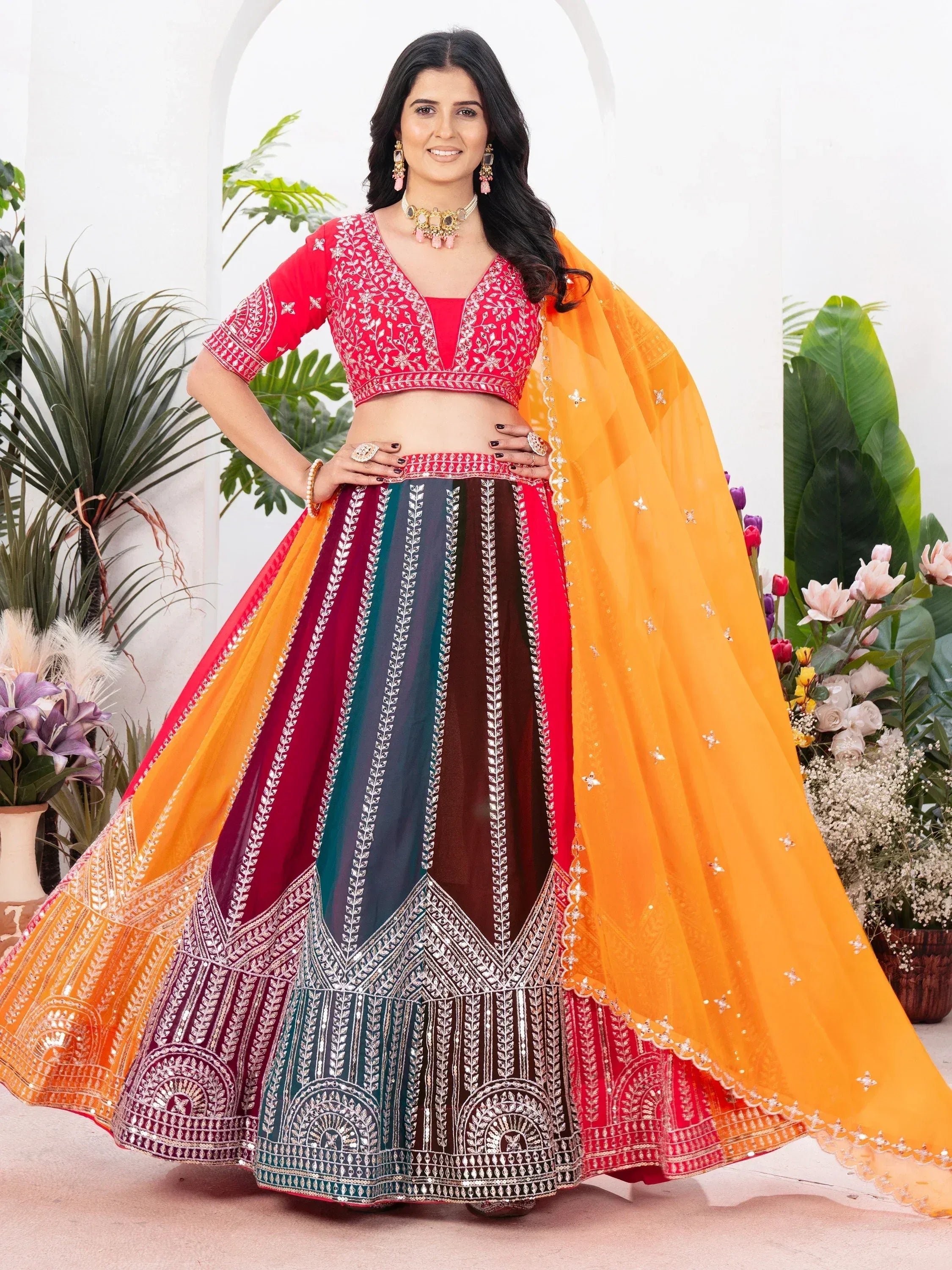 Vibrant red embroidered lehenga choli with multicolor skirt and orange dupatta, perfect for Indian ethnic occasions.
