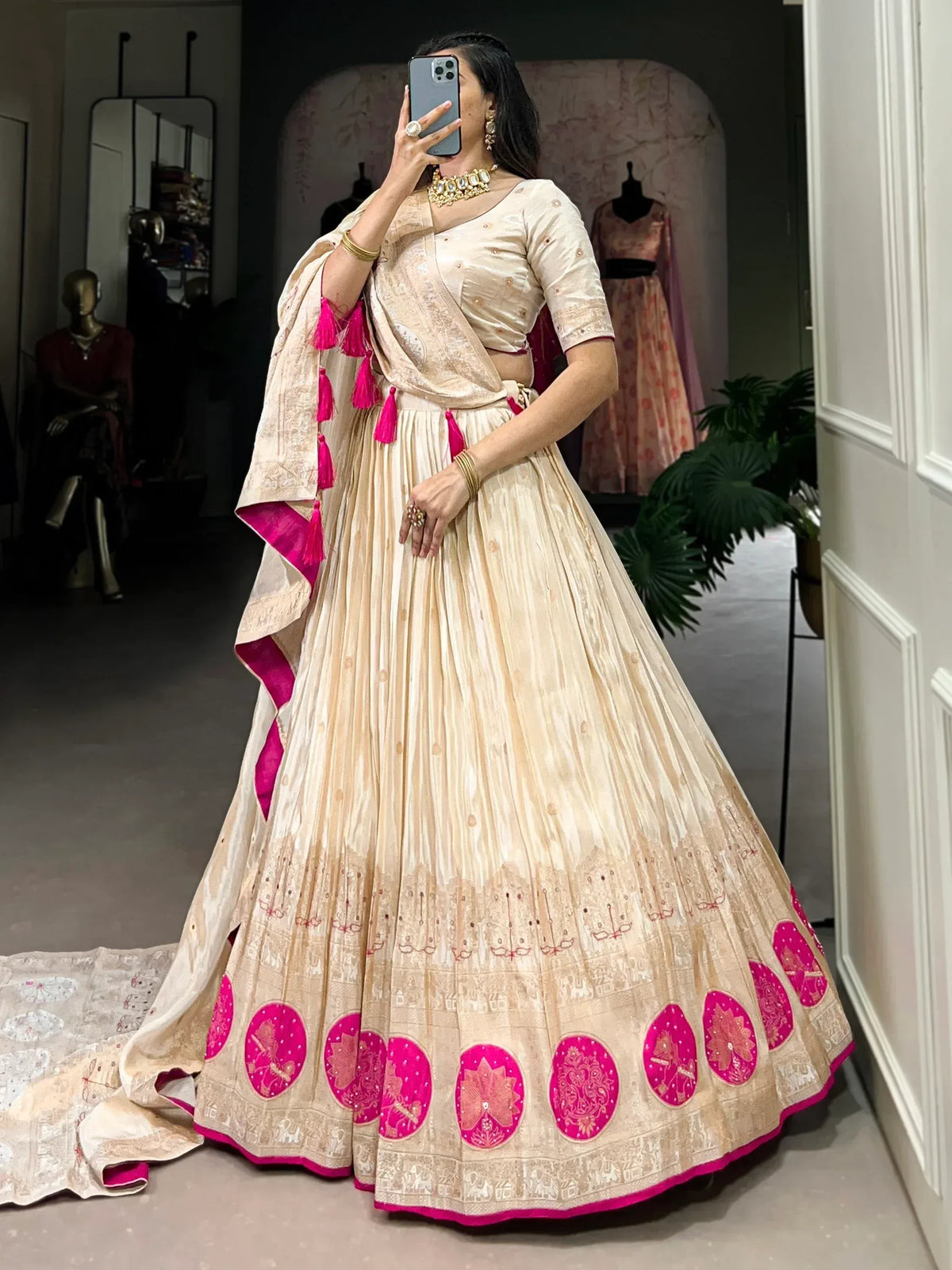 Cream and pink embroidered lehenga choli with tassel dupatta, perfect for Indian weddings and festive occasions.