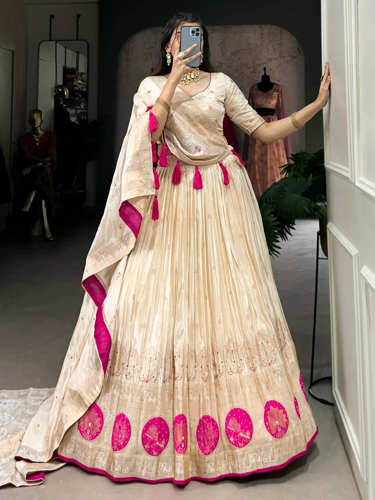 Cream and pink embroidered lehenga choli with tassels and floral motifs, perfect for Indian ethnic occasions.