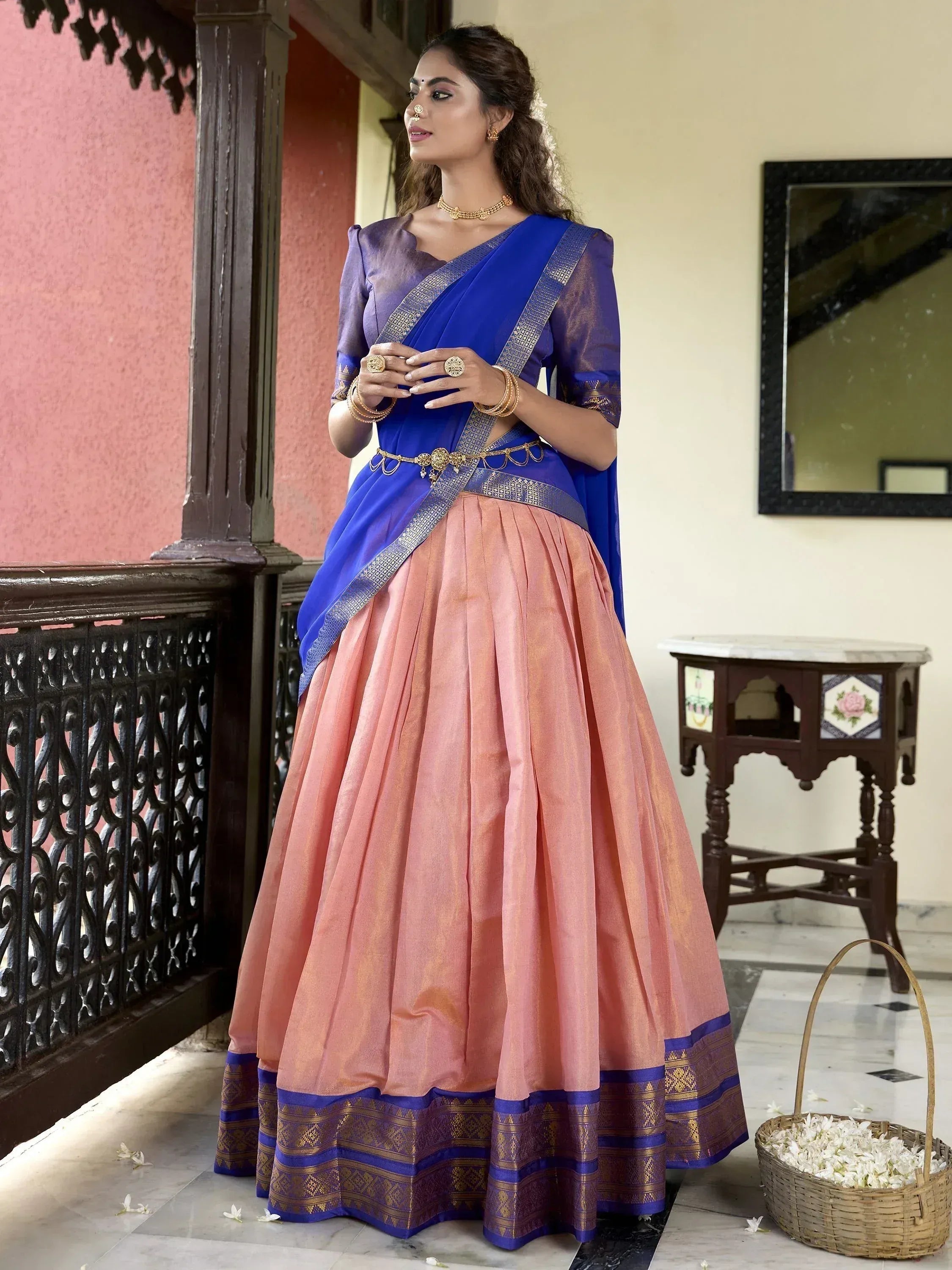 Woman in blue and peach designer lehenga choli with gold embroidery, traditional Indian ethnic wear