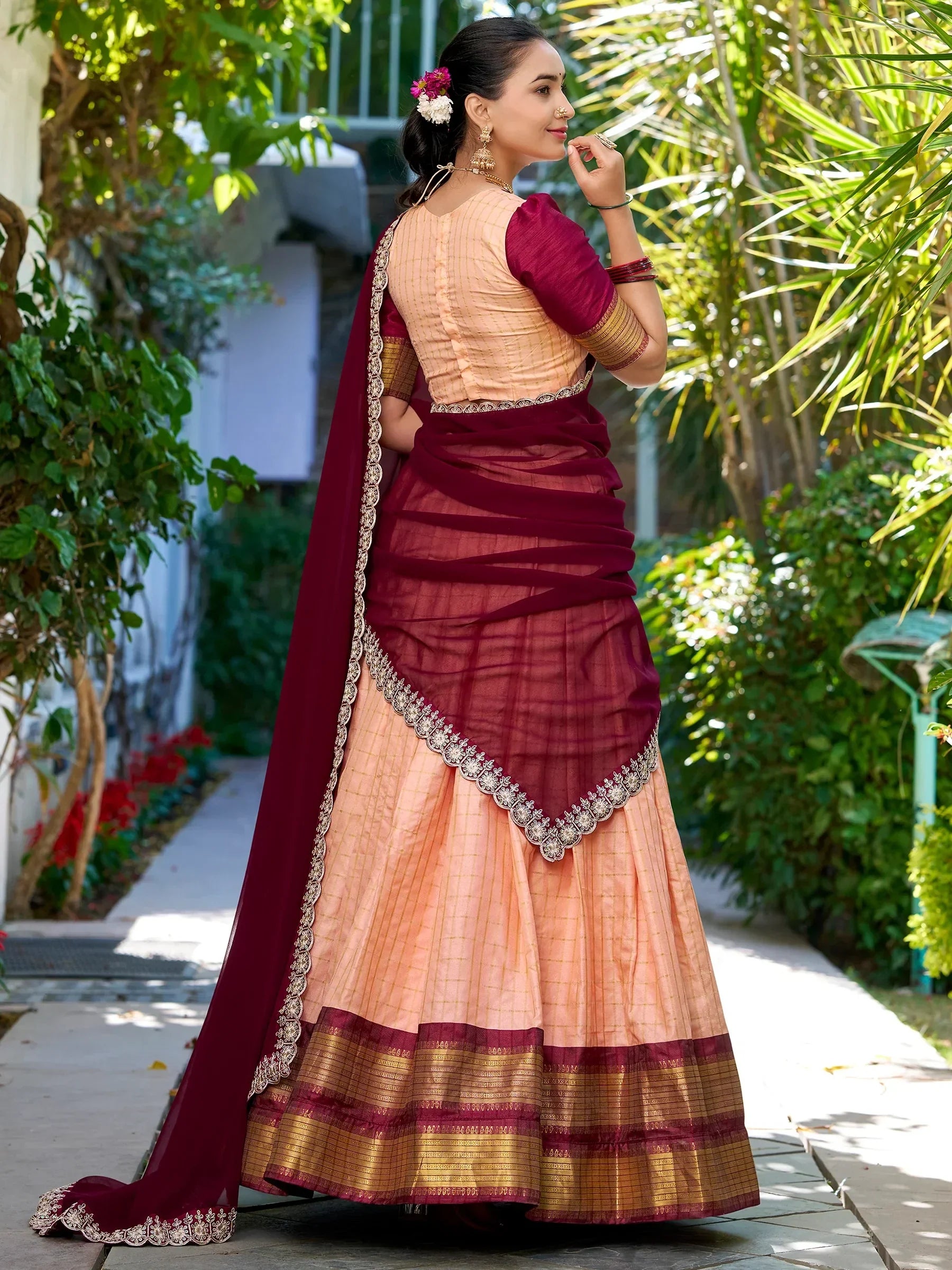 Elegant maroon and peach lehenga choli with intricate gold embroidery, perfect for Indian ethnic wear.
