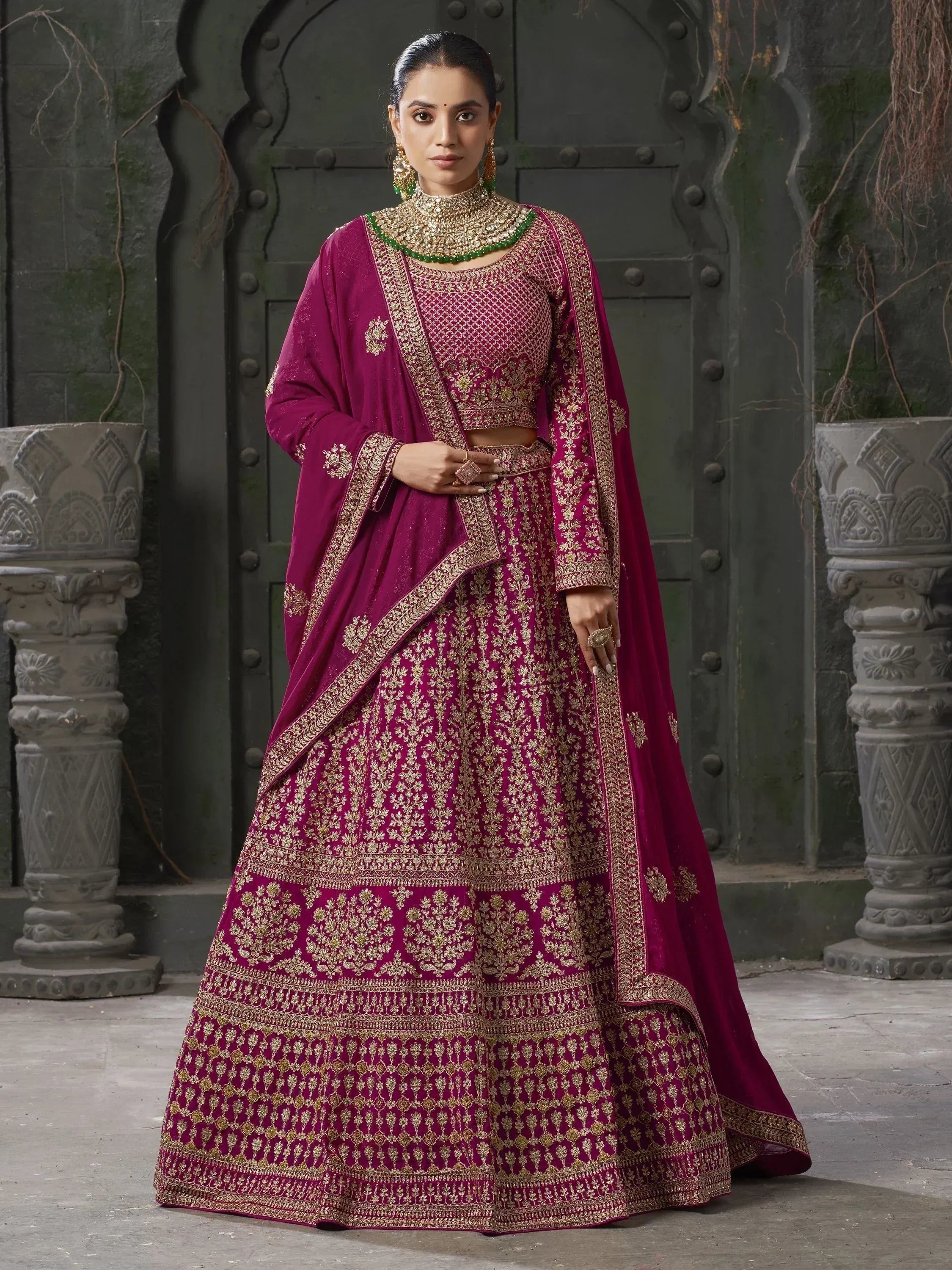 Magenta designer lehenga choli with gold embroidery, perfect for Indian weddings and festive occasions.