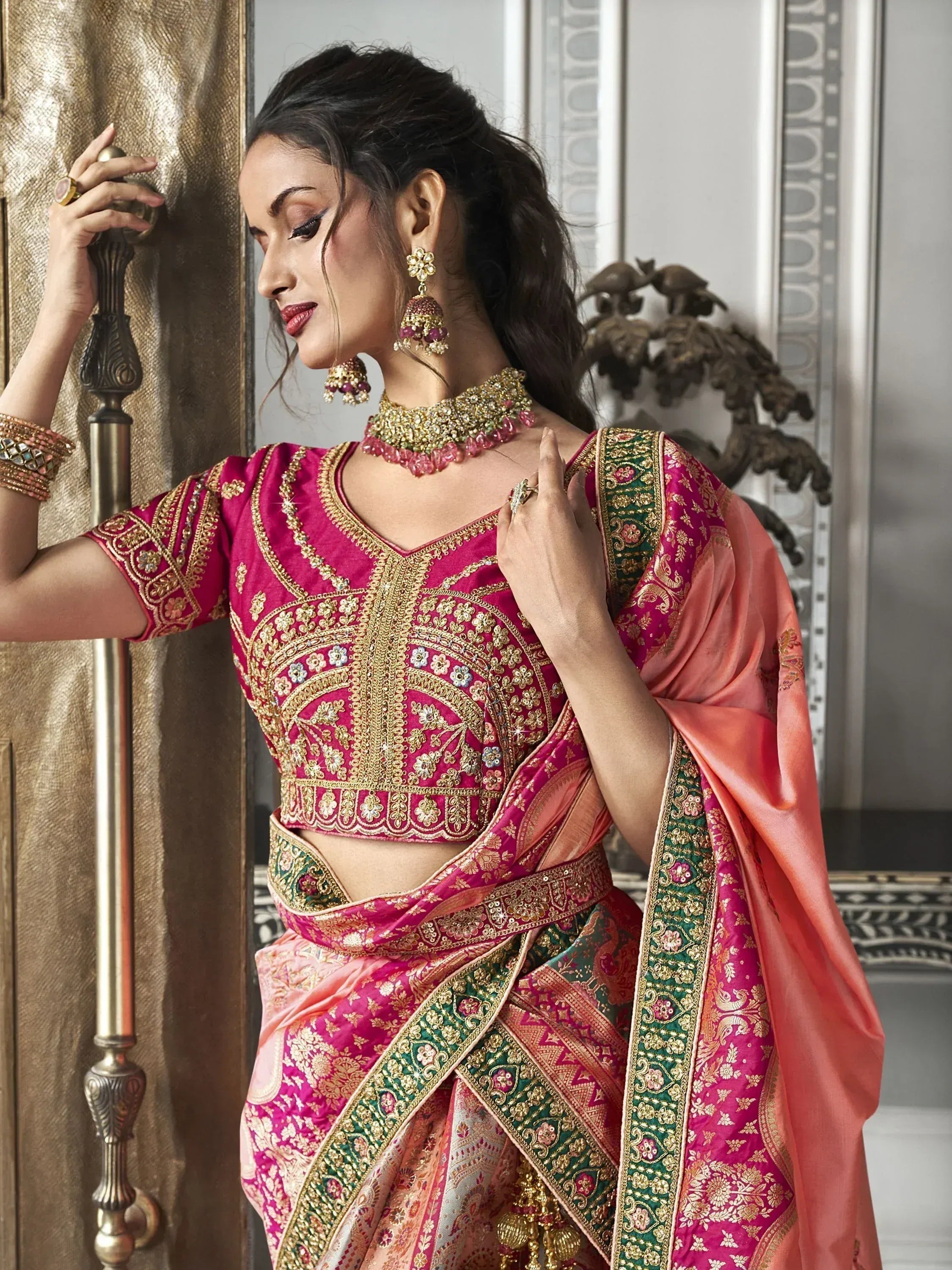 Woman in pink and gold embroidered lehenga choli with matching dupatta, traditional Indian ethnic wear