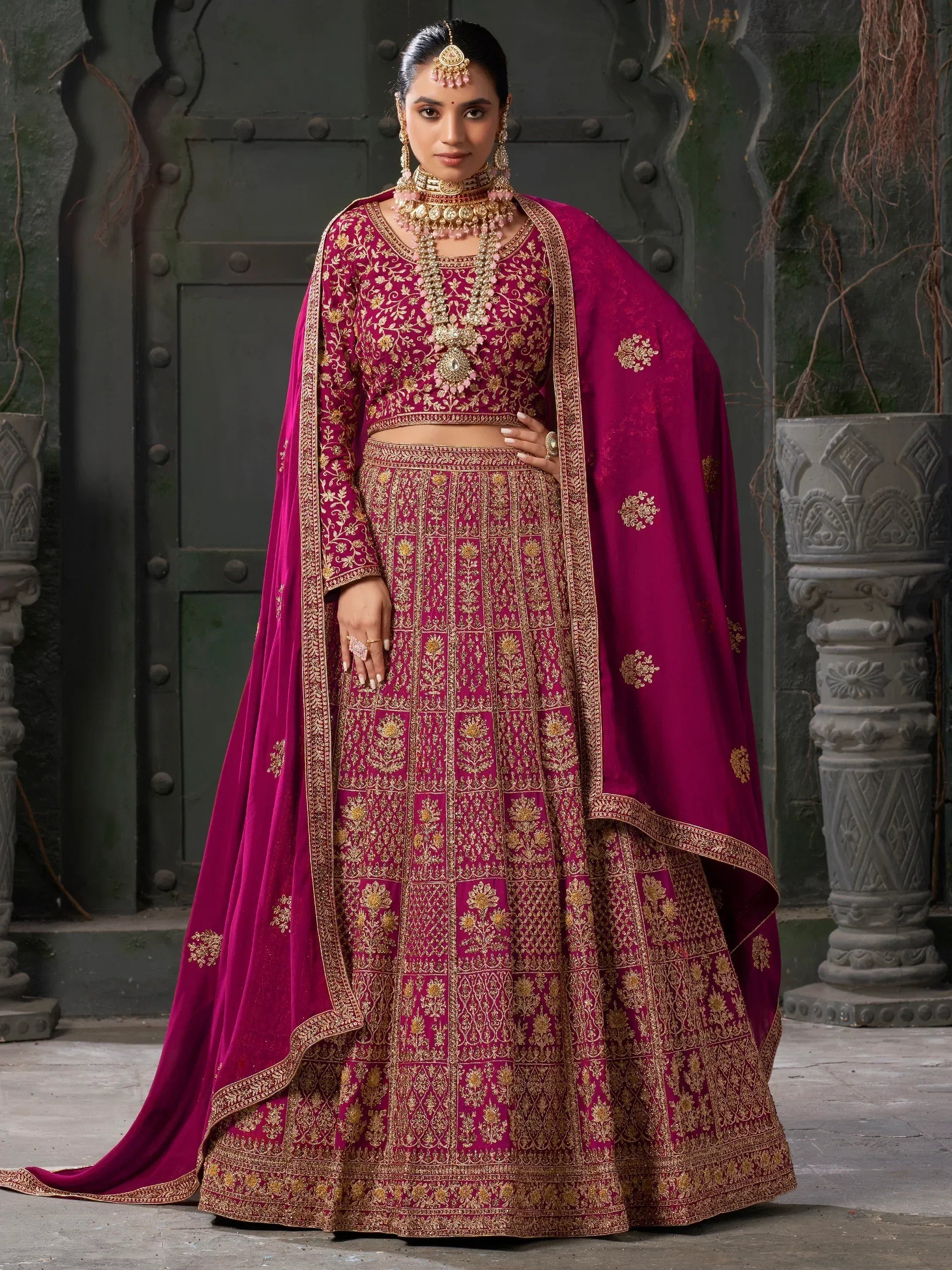 Magenta designer lehenga choli with gold embroidery, perfect for Indian weddings and festive occasions.