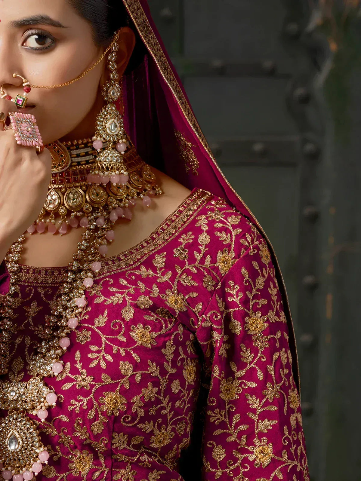 Elegant maroon lehenga choli with gold floral embroidery and traditional Indian jewelry