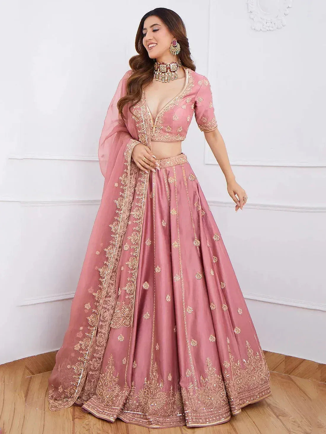 Pink embroidered lehenga choli with gold detailing, perfect for Indian weddings and festive occasions