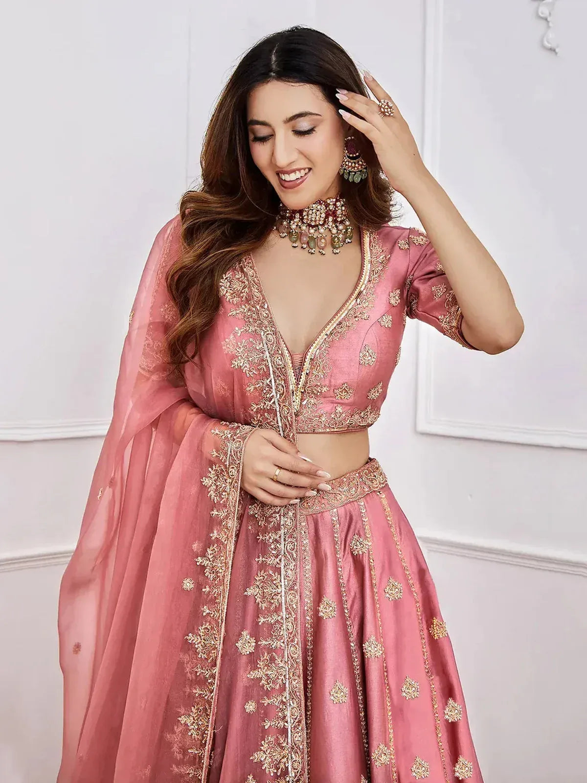 Pink embroidered lehenga choli with gold detailing, perfect for Indian weddings and festive occasions.
