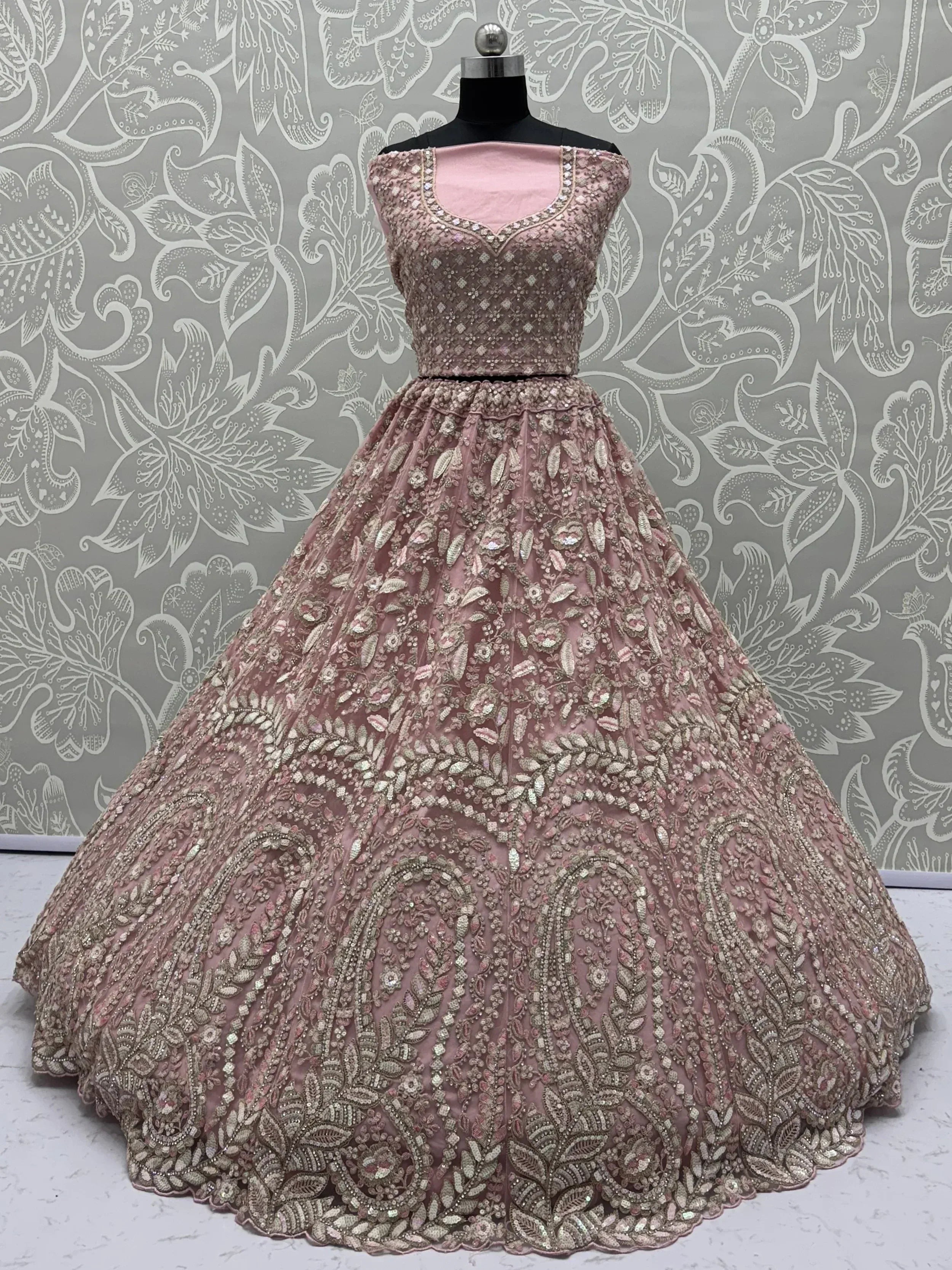 Elegant pink designer lehenga with intricate gold embroidery and floral patterns, perfect for Indian ethnic wear.
