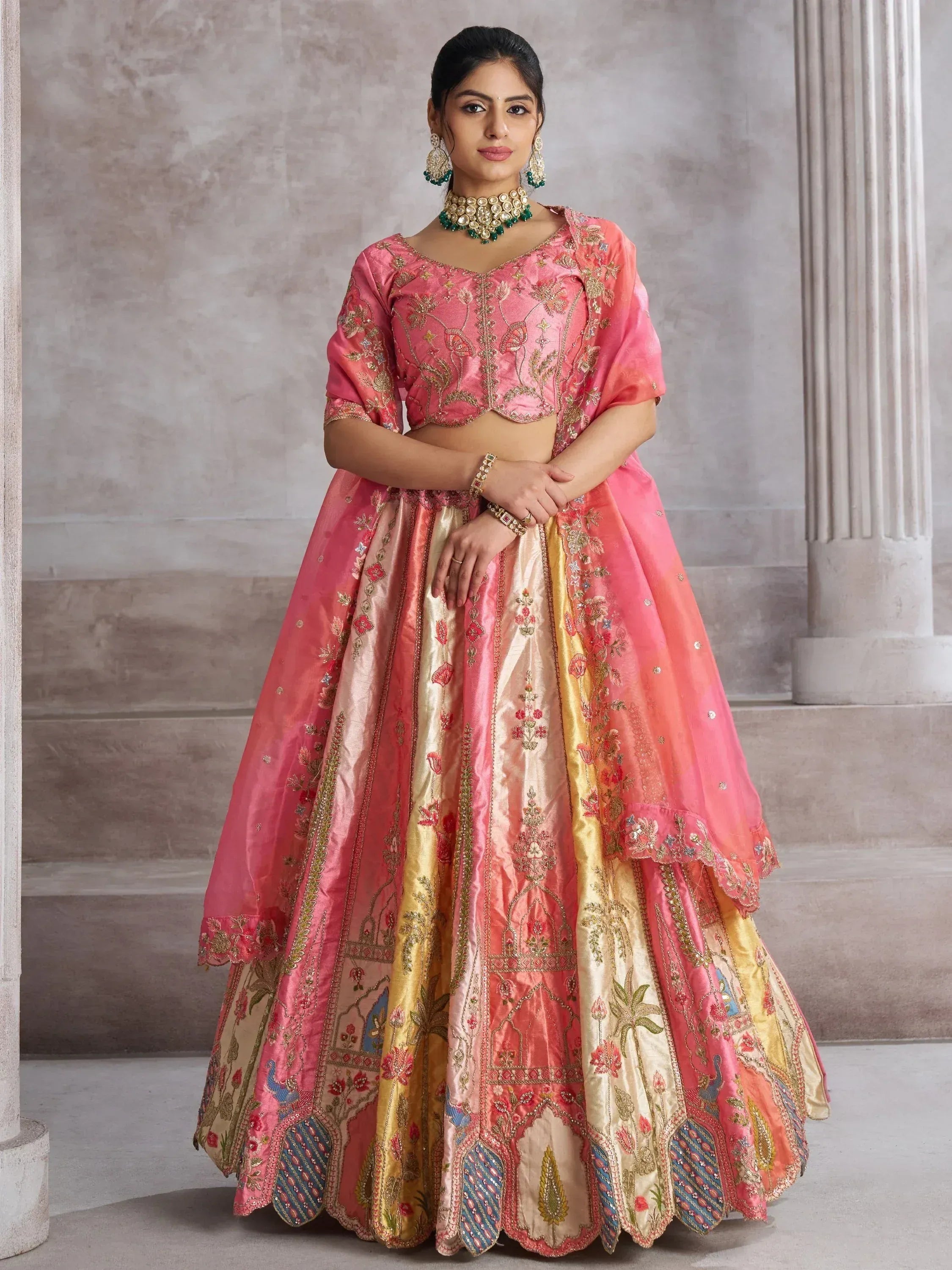 Pink and gold embroidered lehenga choli with floral motifs, perfect for Indian weddings and festive occasions.